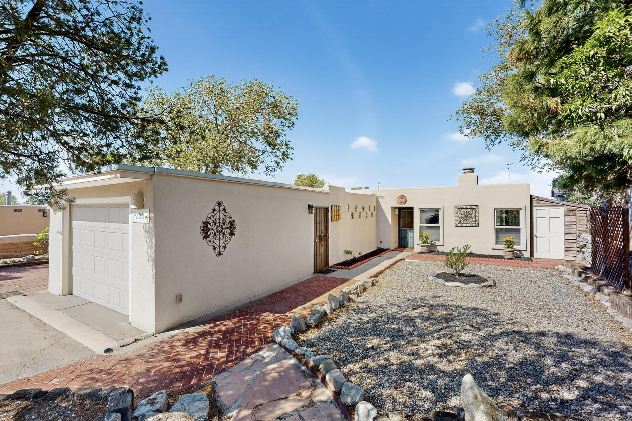 Full of Southwest Charm, this home showcases handcrafted artistic details and the most beautiful sunset and city views! Features include wood-beamed ceilings, adobe accents, brick and tile floors, stained glass and a custom fireplace with built-in seating areas. The galley kitchen offers granite counters, SS appliances, recessed lighting, built-in shelves and a bar with seating that opens to the living space. The primary suite offers a full bath while two guest rooms enjoy access to a private courtyard with a covered patio and breezeway leading to the oversized garage and garden/storage shed. Added comforts include refrigerated air and updated windows. The backyard highlights unobstructed views with no neighbors directly behind, a covered patio, tranquil Koi pond, and attached workshop.
