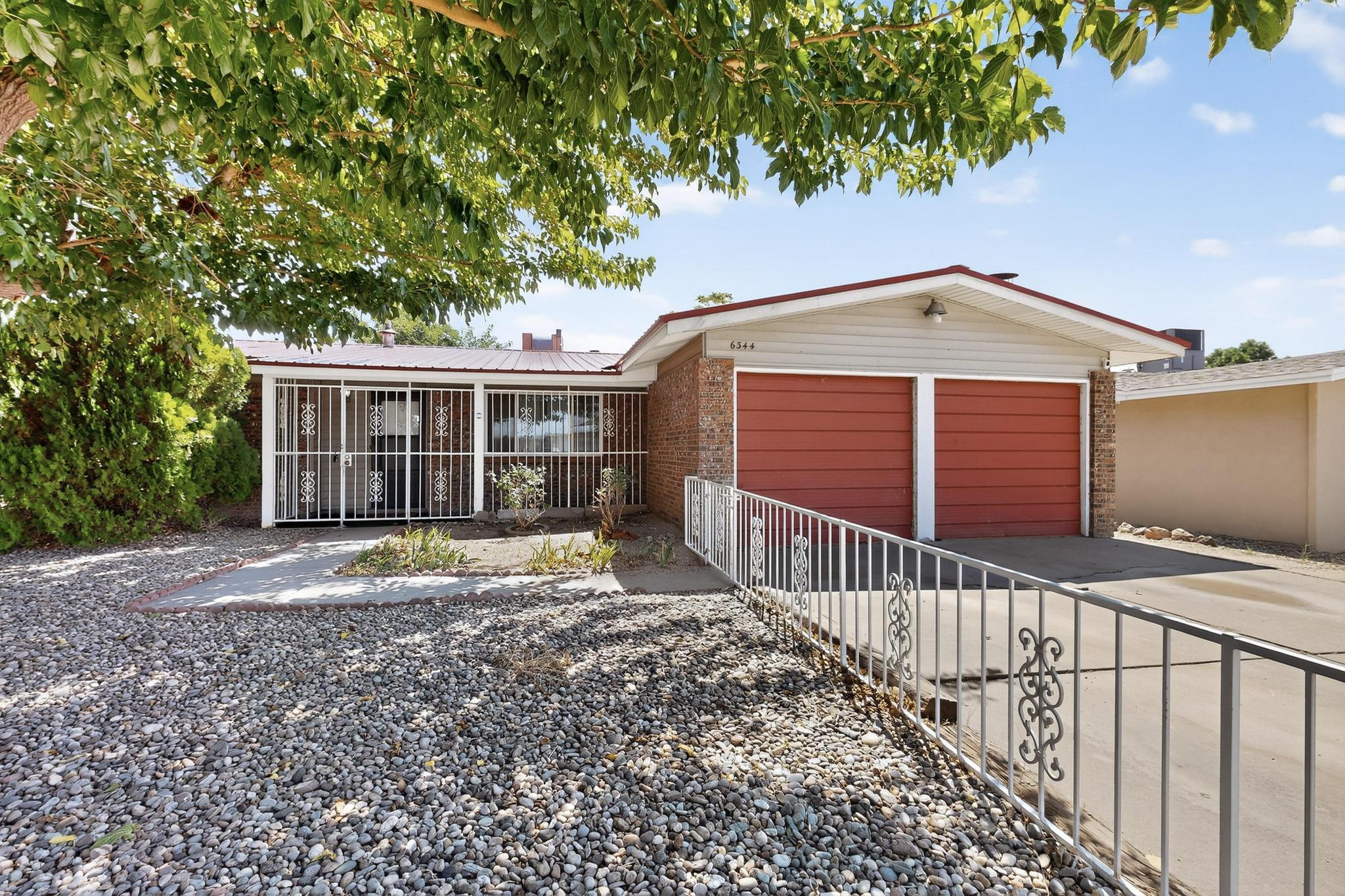Updated **Presley-built** single-story in Academy Acres! This 3 bed, 2 bath home offers 1,447 sq. ft. with 2 living areas and 2 cozy wood-burning stoves. Features include a **metal roof**, updated bathrooms, newer windows, newer furnace, new water heater, and a converted garage for added versatility. Enjoy a covered back patio, backyard with dog run, and new pump in the evaporative cooler. Bright open layout with spacious dining and kitchen areas. Convenient NE Heights location close to parks, schools, and shopping. **Don't miss thisopportunity!**