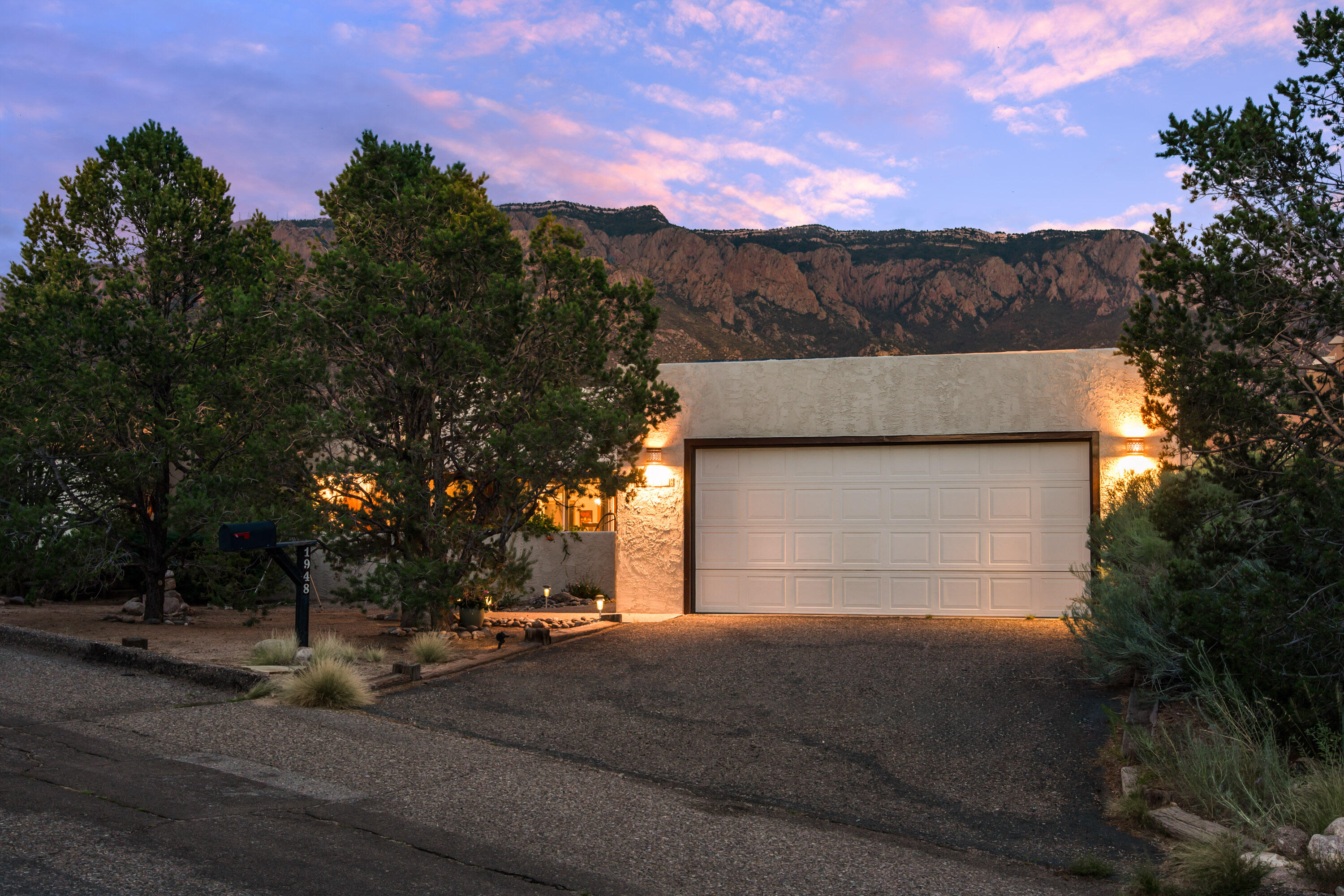 Nestled in the highly sought-after Sandia Heights community, this thoughtfully updated home showcases breathtaking views of the Sandia Mountains and is filled with natural light from its abundance of windows. The stunning kitchen is a true showpiece, featuring custom cabinetry, Taj Mahal Quartzite countertops, porcelain tile flooring, and JennAir appliances--including a built-in panel refrigerator, induction cooktop, steam oven, and convection oven. The spacious living room offers a cozy Kiva fireplace. Designer lighting accents that create warmth and character throughout. Updated bathrooms feature stylish fixtures and countertops. Step outside to a serene backyard with mountain views, where deer are frequent visitors, making this property a rare blend of natural beauty and refined design.