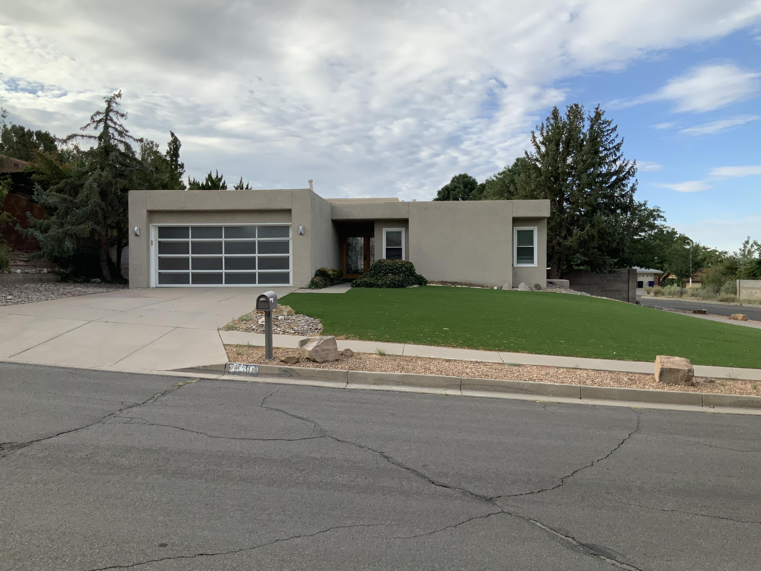 Beautifully modern home featuring spectacular Sandia Mountain views in desirable NE Heights location. Brand new flooring throughout creates a light and bright atmosphere perfect for contemporary living.  Easy-care landscaping for low maintenance lifestyle.  Private putting green in backyard.  Beautiful covered patio ideal for outdoor entertaining.  Move-in ready with fresh updates throughout.  Peaceful mountain setting with city convenienceExperience luxury living with breathtaking views and thoughtfully designed outdoor spaces. This turnkey home offers the perfect blend of modern comfort and Southwest charm.  Contact us today to schedule your private showing!