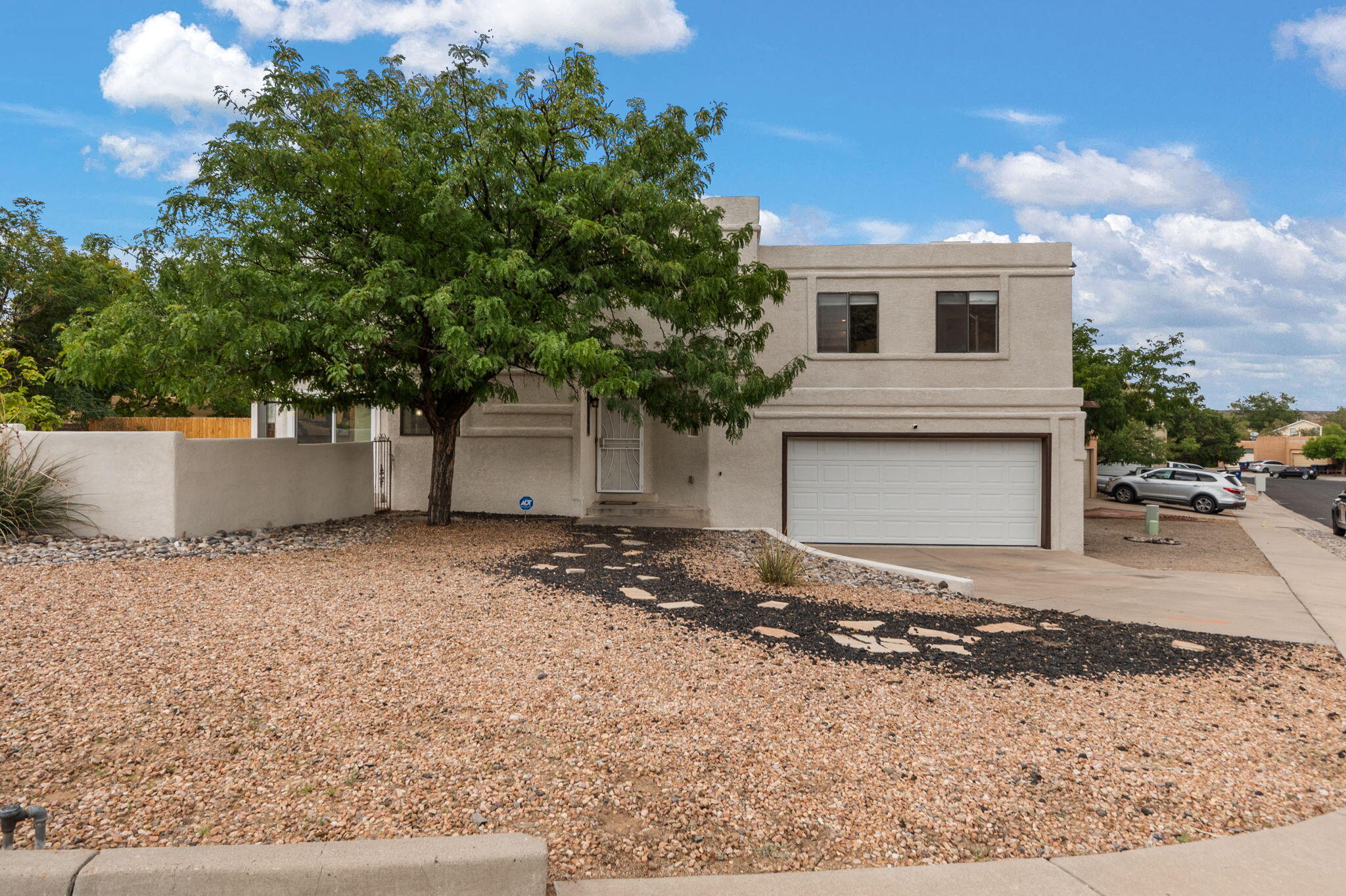 Just around the corner from the Petroglyph National Monument Visitor Center, this beautiful split-level home offers space and style! The main level features an elegant living room, dining area, updated kitchen, and a guest bathroom. The converted garage downstairs provides a spacious family room, while the upper level boasts a large primary suite, two additional bedrooms, a bathroom, and laundry. With two inviting living areas, updated flooring throughout (no carpet), and extensive outdoor space perfect for gardening, entertaining, or play, this home is move-in ready with inspections and repairs already complete!