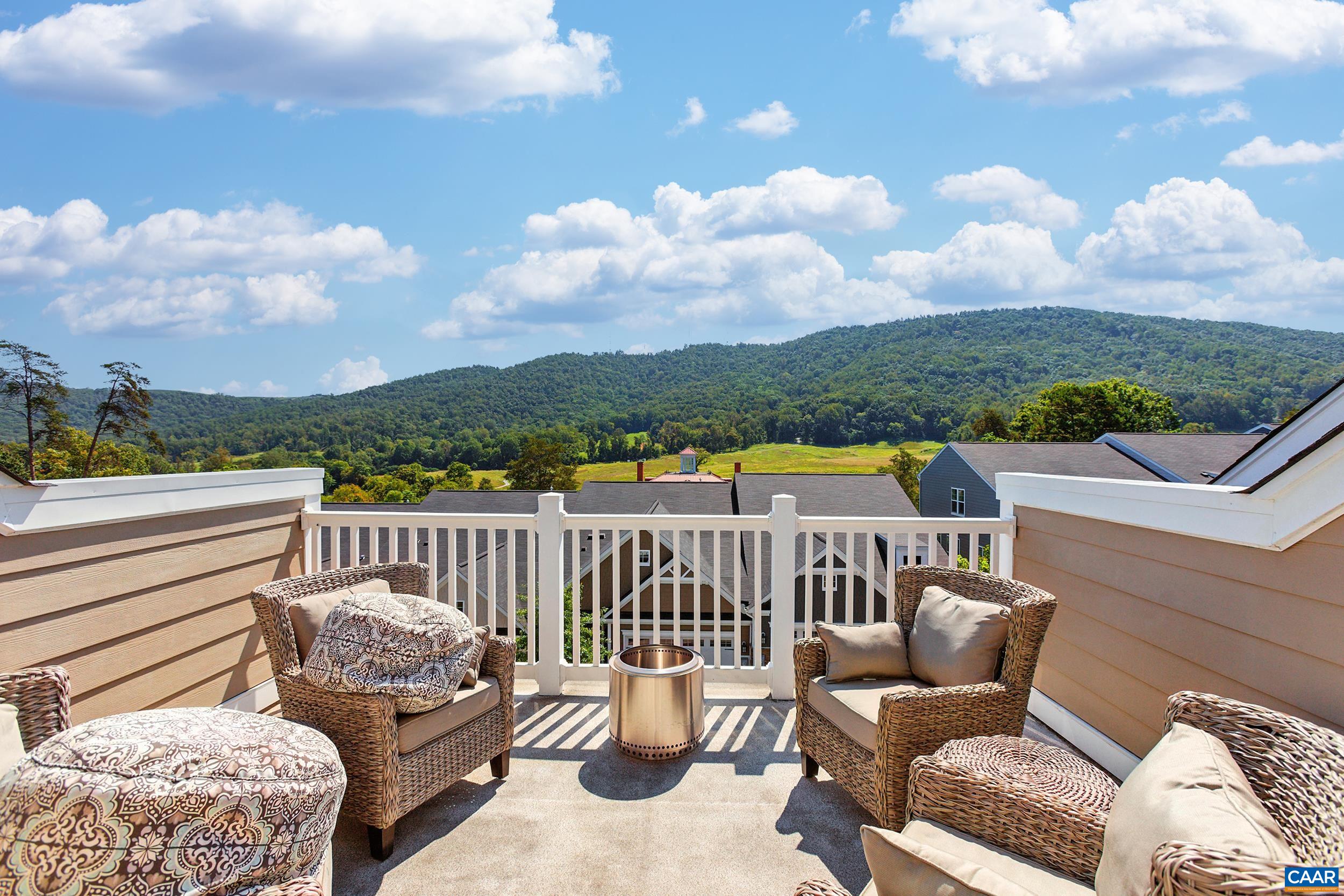 Welcome to this beautifully maintained Charlottesville townhome offering four bedrooms and three and a half bathrooms. Built in 2020, this home still feels like new, with stylish finishes and thoughtful design throughout. Luxury vinyl plank flooring spans the entry and main levels, paired with recessed lighting that adds warmth and a modern touch.  The entry level features a private bedroom with an ensuite bath—ideal for guests or multigenerational living. Upstairs, the main level boasts an open-concept layout with a bright kitchen and dining area. Enjoy granite countertops, a large center island, white cabinetry, and stainless steel appliances, all highlighted by a modern farmhouse chandelier and pendant lights. The dining area flows seamlessly to a private deck, perfect for indoor-outdoor living.  Carpeted upper-level bedrooms include a peaceful primary suite with its own ensuite bath. The top-floor loft offers additional living space and opens to a rooftop deck with stunning views of Carter Mountain.  Community amenities include a dog park, clubhouse, playground, and a fully equipped gym. This home is ideally located near UVA, Downtown Charlottesville, and major commuter routes. Don't miss out, book your tour today!