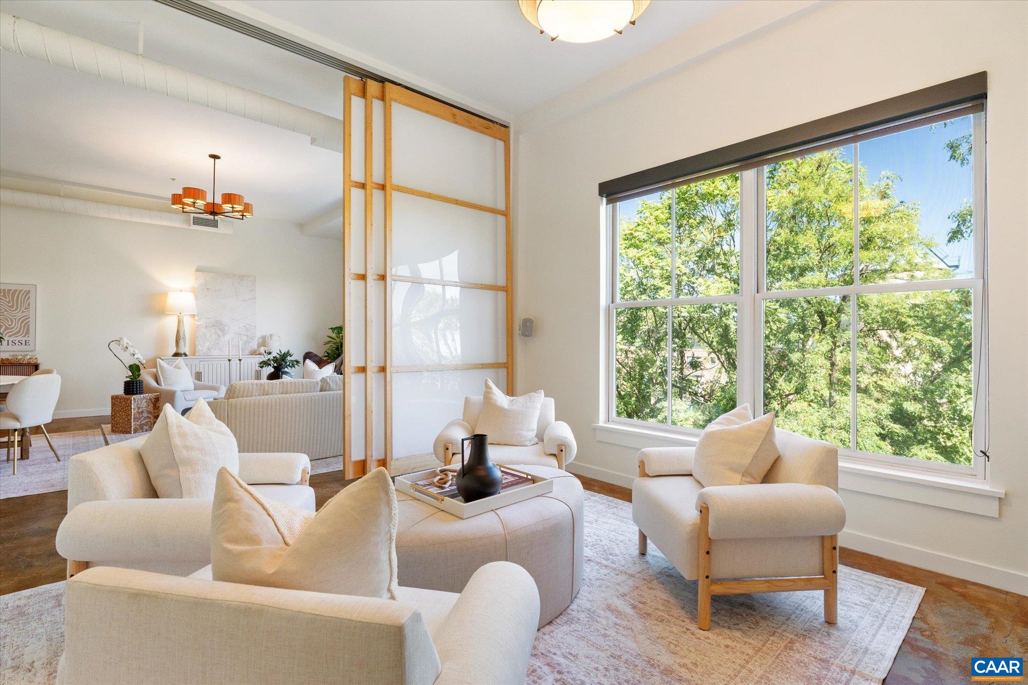 Chic and contemporary, this two-story condo in Belmont Lofts combines modern design with an unbeatable location. The main level features soaring ceilings, an open-concept floor plan, and expansive windows framing both urban and verdant views. The kitchen and living area connect seamlessly, while custom Shoji panel flex walls provide the option for a den or main-level bedroom. Finishes include concrete, hardwood, and ceramic tile flooring, maple cabinetry, and fresh updates with new paint and appliances throughout. A bright stairwell leads to the private rooftop terrace—perfect for entertaining or relaxing above the city. Upstairs, the spacious owner’s suite offers a walk-in closet, additional hall closet, and a full bath. This unit includes a secure storage area, one assigned indoor garage space within a gated entry, plus an extra unassigned outdoor parking spot. Association fees cover trash and recycling, water, sewer, gas, and all exterior maintenance for truly low-maintenance living. Set on several landscaped acres with its own courtyard and gardens, this community provides a private retreat in the heart of Charlottesville—just a short walk to Belmont’s shops and restaurants, IX Art Park, and the Downtown Mall.