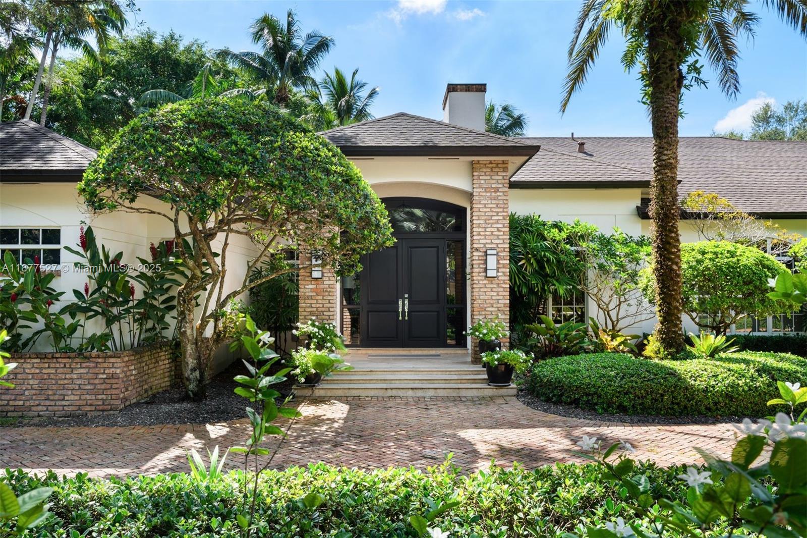 Nestled on a quiet cul-de-sac in prestigious North Pinecrest, this stunning estate offers 6 BD, 6.5 BA, and over 8,000 total SF of refined living. Set on a lushly landscaped acre with specimen palms, the home boasts soaring ceilings, Italian porcelain floors, a custom bar, wine room, home theater, and gym. The gourmet kitchen features Sub-Zero/Miele/Wolf appliances, marble counters, and custom cabinetry. The expansive main suite includes a sitting area, office, dual walk-in closets, and spa-like bath. Resort-style outdoor living offers a saltwater pool with waterfall spa, covered terrace, summer kitchen, tiki hut, and basketball court. Additional features: 3-car garage, full-home generator, smart systems, and full security. A rare Pinecrest offering blending luxury, comfort, and privacy.