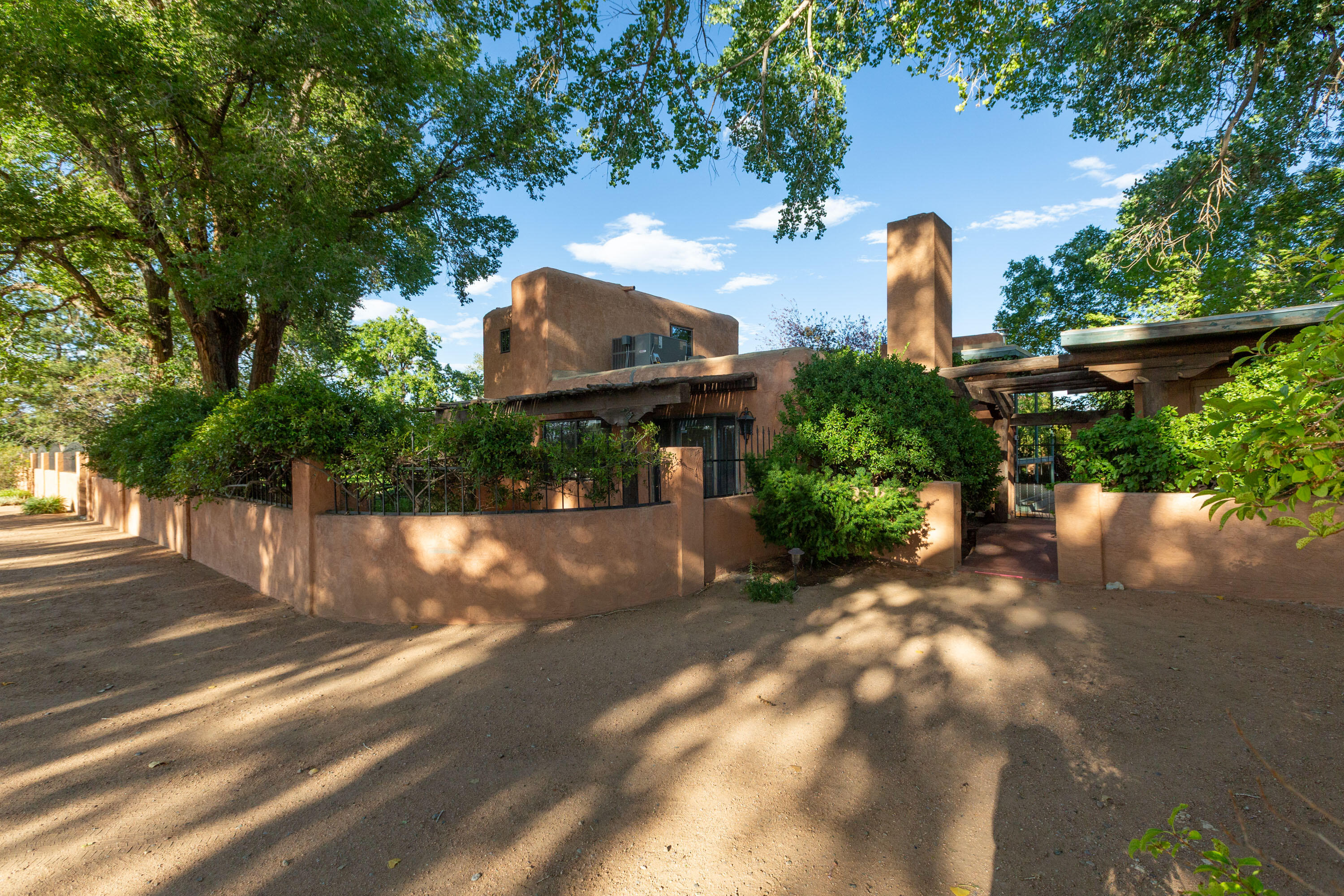 Incredible home in Valley Farms on approx 3 acres!  An oasis of lush landscaping, grass, shade trees, shrubs & beautiful outdoor patios for entertaining!  Old world charm & character,, kiva, banco, wet bar, floor to ceiling windows showcasing spectacular grounds & natural light!  Refrig Air. New sewer line connection. Kitchen features granite countertops, wood floor, breakfast nook, R/O sys, huge walk-in storage pantry plus cabinet pantry. Formal dining room. Two bdrs on the main floor with updated baths plus upstairs bdr with half bath. Huge living room features a gas fireplace with brick hearth & private oourtyard patio. Electric property gate, 960sf workshop/2CG w/metal roof, greenhouse/sunroom, and extended carport.