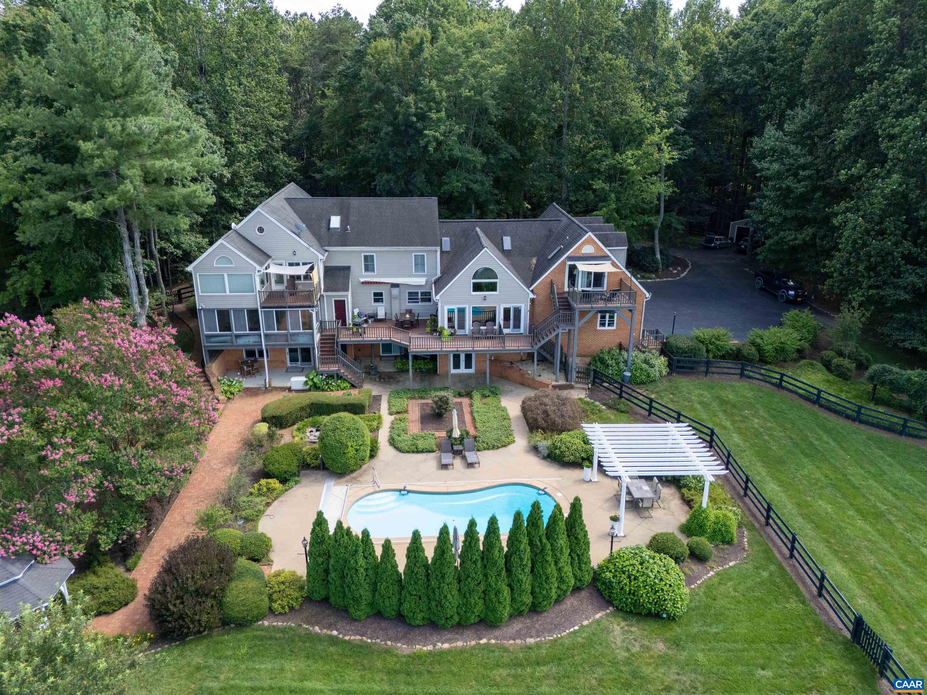 Blue Hill Farm provides fine Virginia country living in an immaculately maintained family home with splendid gently rolling mountain views. The private and manageable 7+ acre parcel is landscaped with mature plantings that include fruit trees, hydrangeas, roses and more with three board wired fencing and a vegetable garden. Main-level primary suite has two custom closets and a stunning bathroom featuring walk-in cypress wood surround shower, standing cast iron tub, Grohe fixtures, double vanities, and separate WC and vanity room. The primary suite is enhanced with its own sun porch that includes a gas fireplace. The open chef's kitchen has an 8-burner gas Thermador range with double ovens plus an electric wall oven and microwave. The second floor has three private suite bedrooms with 2.5 en-suite bathrooms, and two guest bedrooms that share a full bath. All doors are solid wood and all CA custom closet fit-outs. Heart Pine floors, hand-set Chippendale railings and plantation shutters throughout. Whole house generator. Large side access three car garage. Detached equipment shed with dog kennel and fenced in yard. Lower level has large guest room, full bath, direct access to pool, and work from home office. A terrific family home.