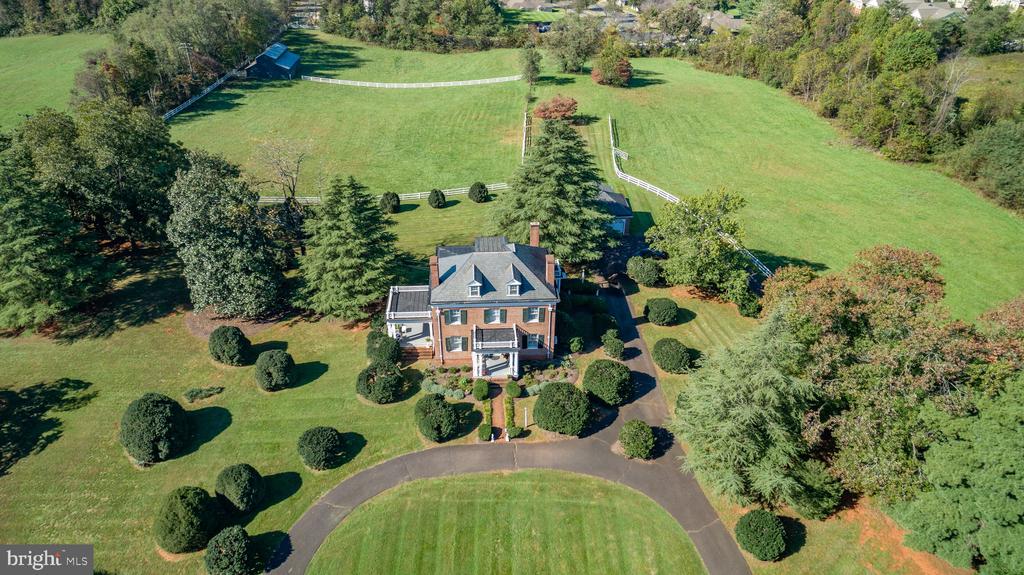 Estate-Style Residence on nearly 10 Acres in the Town of Orange Welcome to this timeless all-brick traditional estate, offering classic elegance and modern comfort on 9 beautifully manicured acres in the heart of Orange, Virginia. This 3-bedroom, 2.5-bathroom residence showcases spacious living areas, fine architectural details, and inviting spaces both indoors and out. A beautiful formal living room sets the tone upon entry, leading to a grand center staircase and dining room, a comfortable family room, and a well-appointed kitchen. Upstairs, you'll find three generously sized bedrooms, a bright sunroom, and a versatile bonus room on the third floor””ideal for a home office, studio, or guest retreat. The home features two fireplaces, a basement for additional storage or future expansion, and large windows throughout that fill the home with natural light. Enjoy outdoor living on the expansive covered porch overlooking the landscaped grounds, perfect for relaxing or entertaining. A detached 2-car garage and barn provide ample space for vehicles, hobbies, or agricultural use. The current zoning also allows muti-family/condos by-right. Conveniently located within the Town of Orange, this property combines the charm of estate living w
