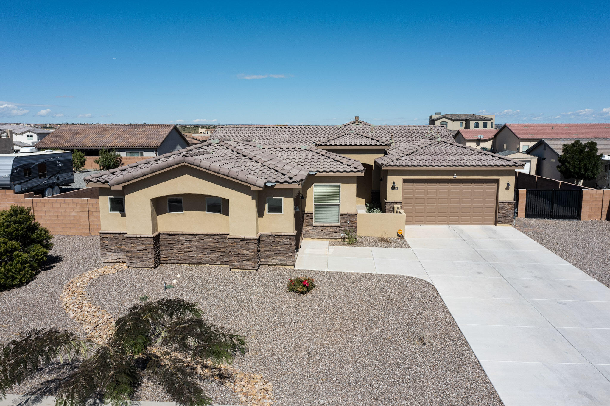 Discover exceptional value in prestigious Petroglyph Estates! Surrounded by million-dollar homes, this custom smart home offers 4 bedrooms plus 3 baths on a generous 0.37-acre lot with RV access and no HOA. The open plan is bright and versatile, with tall ceilings, arched details, and large, beautiful windows that flood the home with natural light. Whether your style leans modern or traditional, soft white interiors provide the perfect backdrop. The primary suite offers a true retreat with soaking tub, dual vanities, and walk-in shower. Three garages, a private courtyard entry, and durable tile roof add convenience and charm. Nearby, scenic bike and walking trails along the escarpment offer endless recreation in one of Albuquerque's most desirable neighborhoods!