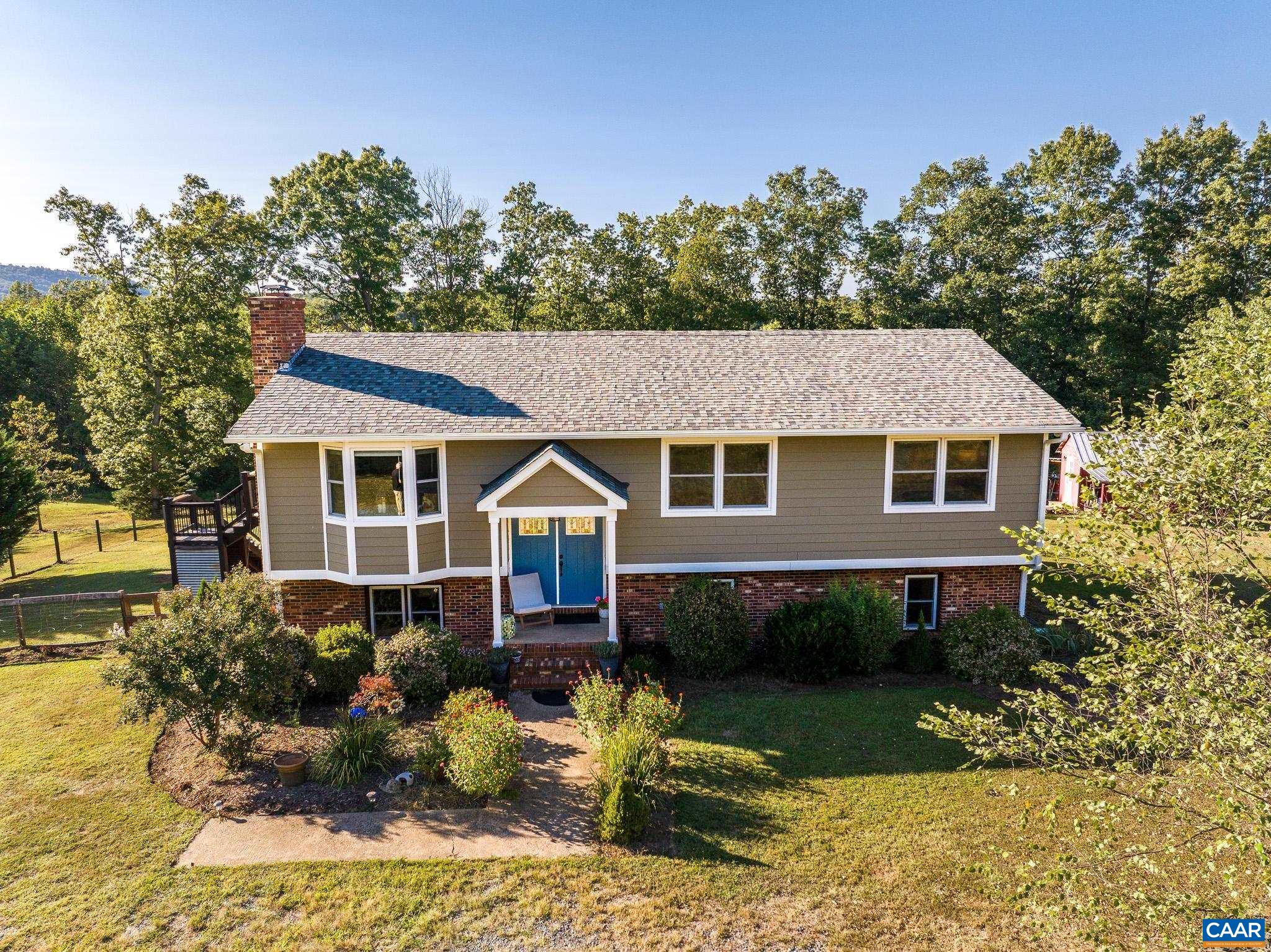 Located near the end of a quiet lane, your new escape awaits. Perfect for a farmette on 4 pastoral acres, this beautifully updated home has been lovingly renovated over time. Step inside to find an inviting living room and a bright, eat-in kitchen featuring locally sourced soapstone counters, a deep farmhouse sink, and abundant cabinetry. From here, walk out to the deck — the ideal spot to enjoy crisp Virginia fall days while taking in peaceful, private views and seasonal mountain vistas.  The spacious primary suite includes a walk-in closet and a full bath with elegant tiled details. Two additional bedrooms and a stylish hall bath with tiled shower complete the main level.  Downstairs, the expansive rec/family room opens to a large patio, offering great space for entertaining or relaxing. You’ll also find a fourth bedroom (currently used as an artist’s studio), a laundry/mudroom, utility room, and a beautifully appointed full bath with both a soaking tub and separate shower with charming tile accents.  Step outside to, enjoy established gardens, a barn with additional lean-to storage, and a detached wooden carport. All this, just 15 minutes from Charlottesville — the perfect blend of country retreat and modern convenience.