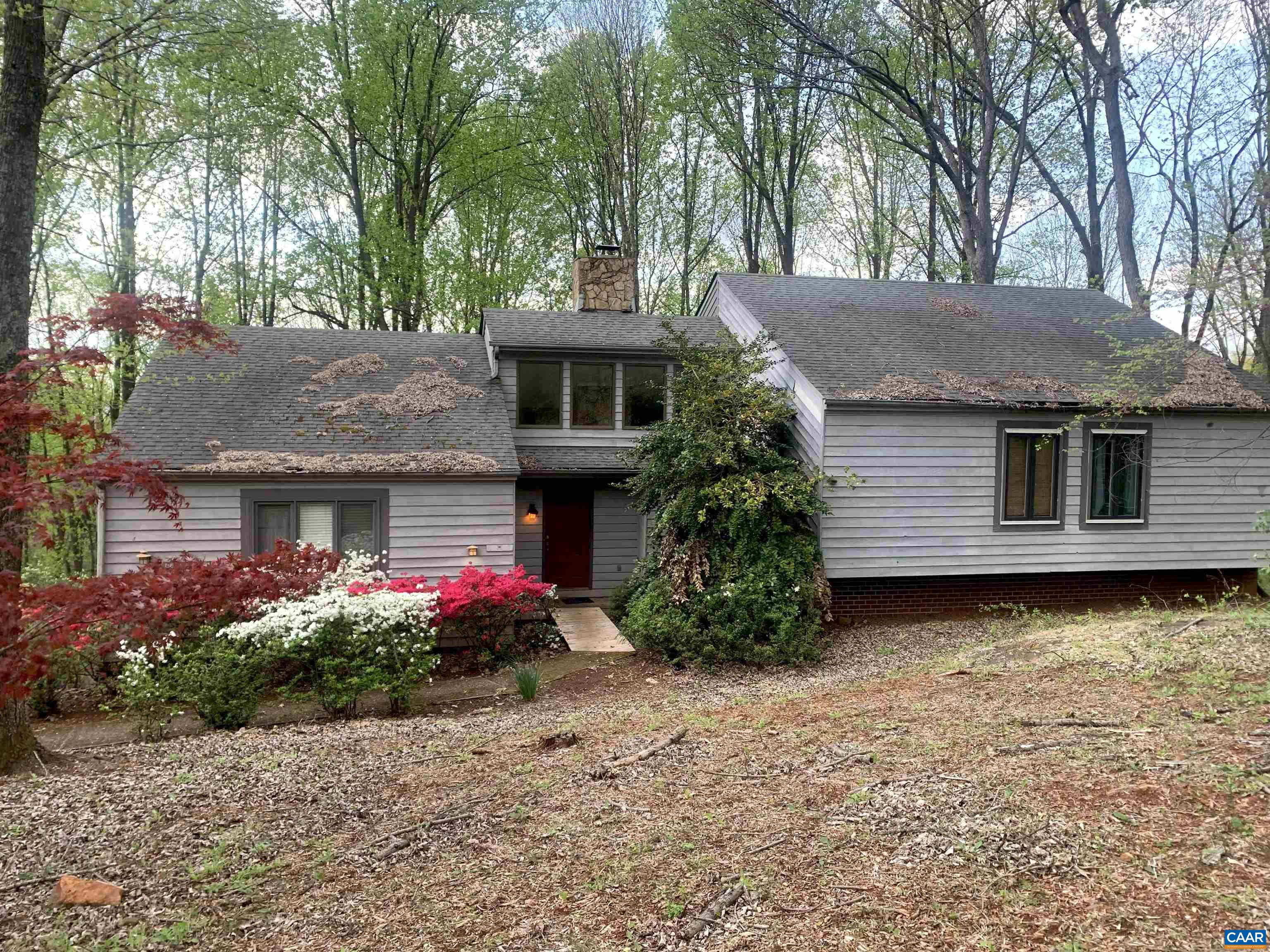 Nestled in the desirable Ashcroft neighborhood, a unique mountainside setting located minutes to Downtown, I-64, hospitals, and shopping. Natural light abounds in this stunning, spacious contemporary on 1.5 private acres, with expansive decks framed by seasonal Blue Ridge views and mature trees. Fenced yard is perfect for pets. This 4BR/3BA home features soaring ceilings, and an open floor plan with dramatic stone fireplace in the living room. The chef in your family will enjoy the kitchen with its large island ideal for gathering and great for entertaining. The primary bedroom suite evokes the feel of a treehouse retreat, featuring large walk-in closet, luxury jacuzzi bath, and its own private deck for enjoying your morning coffee among the treetops and mountains. The additional bedrooms are generously sized, with large closets and ceiling fans. The lower level features a large family room with built-in shelves, ideal for a theater or playroom, the fourth bedroom or guestroom, and full bath with laundry. Expansive two-car garage with cabinets and workspace. With access to Ashcroft’s miles of walking trails, pool, tennis, and clubhouse, this home offers the best of mountain living with the convenience of town just minutes away.