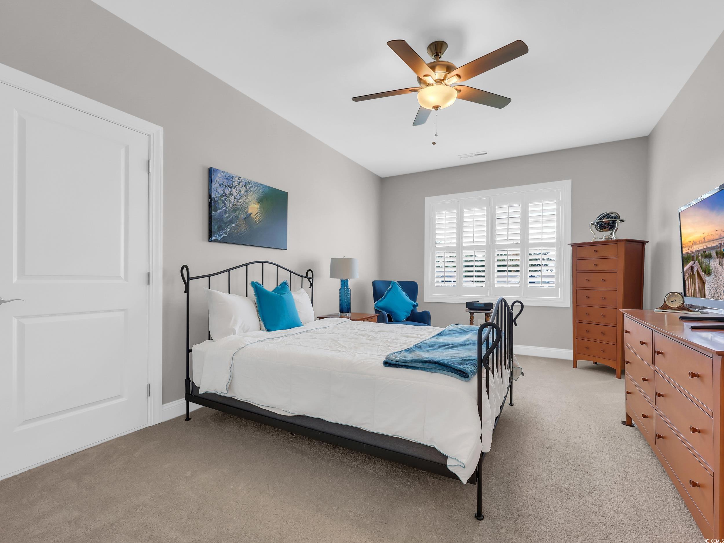 Bedroom featuring light carpet and a ceiling fan