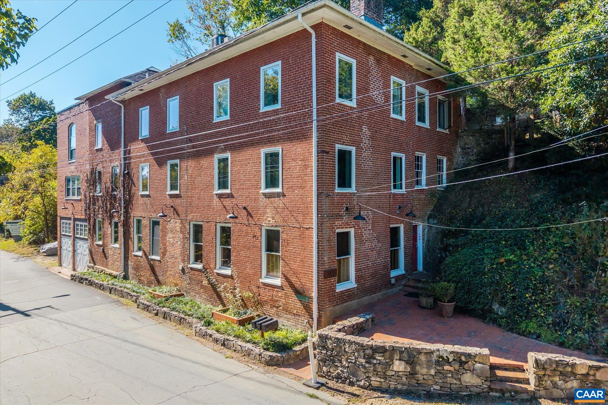 Perched above the Rivanna River, The Millhouse is a historic 1850s Woolen Mills building thoughtfully transformed into three distinctive residences. Originally the Woolen Mills office, the building’s rich character endures, highlighted by a striking stone outcropping at the shared entrance. This top-floor condo spans the 2nd and 3rd levels and showcases timeless details—heart pine floors, exposed brick walls, custom built-ins, and a gas fireplace. The 2nd-floor entry includes the foyer, living room, kitchen, and laundry, while the 3rd floor features a generous primary suite with river views, an additional bedroom with a full hall bath, and a loft space ideal for an office or guest room. Two garage bays offer convenient shared storage, and a private rear deck provides space for gardening and outdoor gatherings. Just around the corner, the vibrant Wool Factory community includes Broadcloth restaurant, Selvedge Brewing, and a boutique coffee and wine shop. Located on the city’s edge with easy access to the Rivanna Trail, The Millhouse is a hidden gem in one of Charlottesville’s most unique neighborhoods.