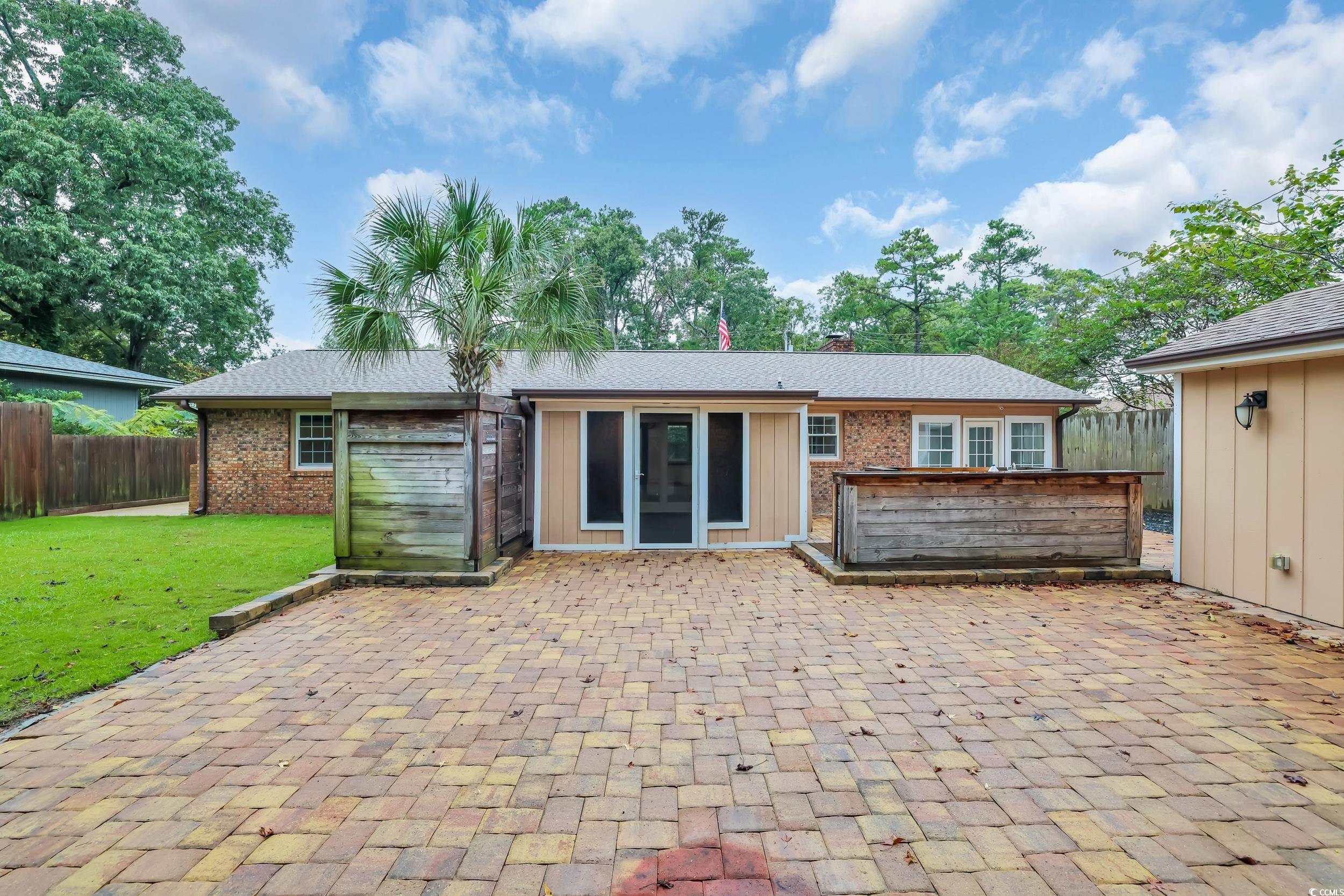 Back of house with a chimney and brick siding