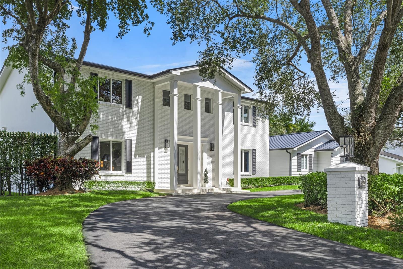 Set on a 21,344 sq ft lot, this stately Colonial-style estate seamlessly blends timeless architecture with modern sophistication. Recently renovated, it offers four generously scaled bedrooms, with three upstairs and one downstairs, a refined study, dual staircases, elegant detailing, and soaring volume ceilings. The gourmet eat-in kitchen is designed for both everyday living and elevated entertaining. Outdoor amenities include a summer kitchen, covered terrace, and heated pool set amid lush, manicured grounds. Additional features include a 4-year-old metal roof, impact glass, impact-rated garage door, 2-year-old generator, and pool heater.