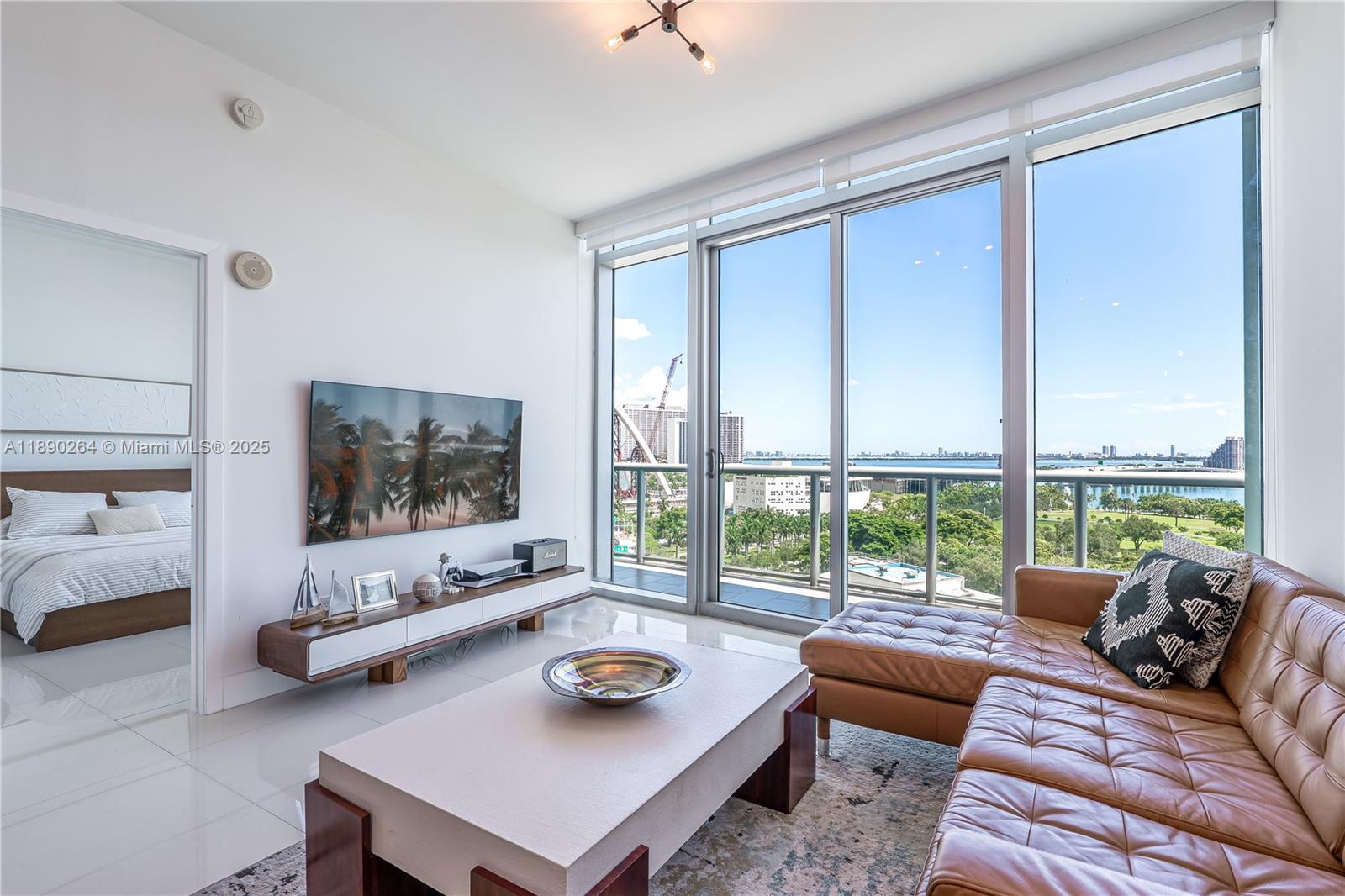 Gorgeous 1 bedroom, 1.5 bath bayfront condo with UNOBSTRUCTED VIEWS, through floor-to-ceiling windows. Featuring extra high 10-FOOT CEILINGS, porcelain flooring throughout, granite countertops, and updated floring in both baths, this unit combines elegance with functionality. Recent upgrades include a new oven, washer & dryer, and custom closet designed to maximize ceiling height. Enjoy the convenience of a parking space in the same floor as the unit plus a storage space. The building offers resort-style amenities: 24-hr concierge, valet parking, two pools, jacuzzi, state-of-the-art fitness center, sand volleyball, business center, party room, BBQ area,  mini market and more. A true lifestyle property with a LARGE BALCONY that is accessed from the living room and the bedroom.