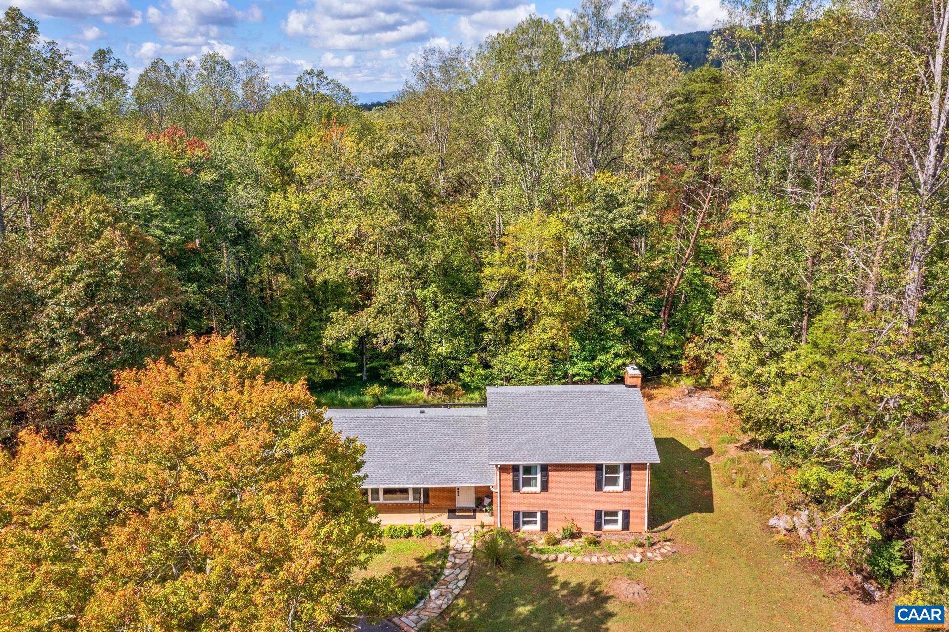 Beautifully renovated home offering the perfect blend of style, space, land, and location! Step into a welcoming foyer that opens to a light-filled living room with original hardwood floors throughout. The updated kitchen features modern finishes and a cozy breakfast nook or coffee bar. Entertain in the spacious dining area or step out onto the oversized deck with peaceful wooded views. Upstairs, find three generous bedrooms, including a primary suite with ample closet space and attached bath. The finished walkout basement boasts a new wood-burning fireplace, an additional bedroom, and full bath, ideal for guests or extended living. A large unfinished basement area offers endless potential for storage, a workshop, or added living space. Nestled on 6.87 acres with a division right in place, perfect for future expansion or investment. Just minutes from Rivanna Station (NGIC/DIA), North Fork Research Park, CHO airport, and shopping, with an easy drive to Downtown Charlottesville and UVA!