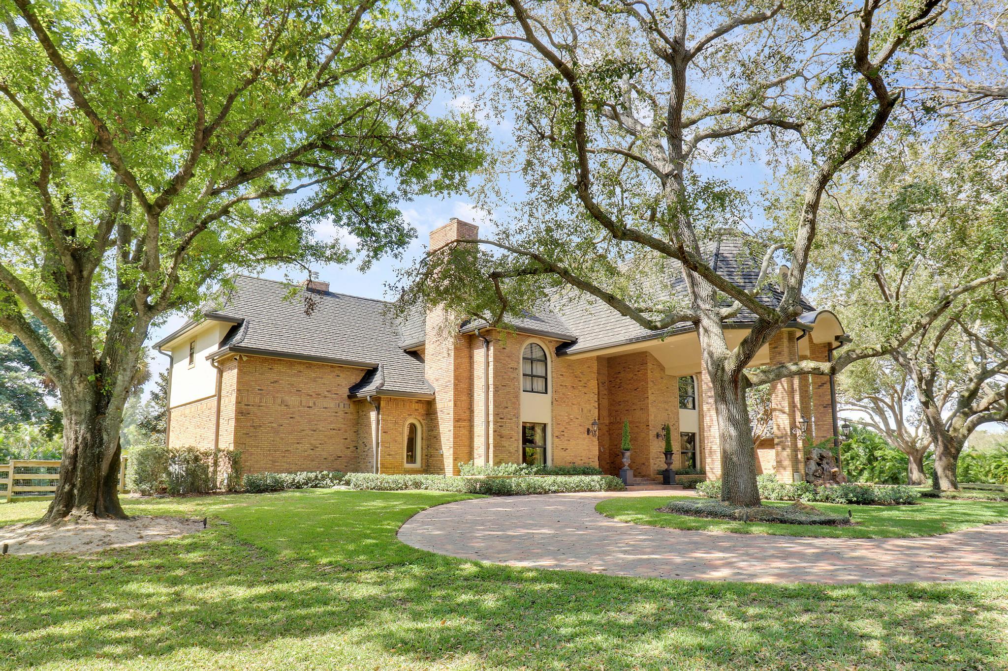 Set on an expansive 2.3-acre lot in the gated community of Steeplechase, this 5-bedroom, 3 full and 3 half-bath home offers privacy, space, and a seamless indoor-outdoor lifestyle.Inside, the open floor plan is bright and inviting, featuring high ceilings, custom millwork, and built-in details throughout. The home has been freshly painted, creating a clean, updated look that complements the natural light and open spaces. The formal living room includes a handcrafted marble wood-burning fireplace, with additional fireplaces in the library and primary suite that add warmth and character. A private guest suite on the first floor includes its own en-suite bath, sitting area, and coffee bar. Every area is designed for comfort, functionality, and flow.