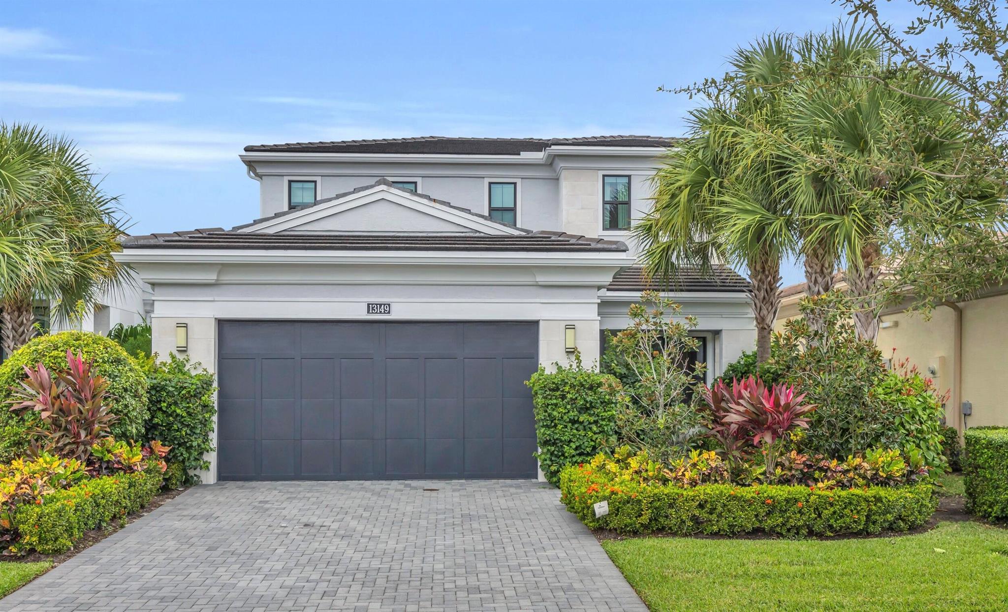 Welcome to the pinnacle of modern luxury in the prestigious, guard-gated community of Artistry. This impeccably designed residence is a masterclass in sophistication and style-showcasing timeless architectural detail throughout. From the moment you enter, you're greeted by a light-filled, open-concept floor plan adorned with rich wood flooring, a dramatic custom great room entertainment center, and expansive windows that bring the lush outdoors in. Every element has been thoughtfully crafted for the most discerning buyer. The formal dining space features a striking custom wine display and bar, setting the tone for elegant entertaining. Just beyond, the gourmet kitchen impresses with top-of-the-line GE Monogram appliances, a gas cooktop, quartz countertops, double wall ovens, a wine