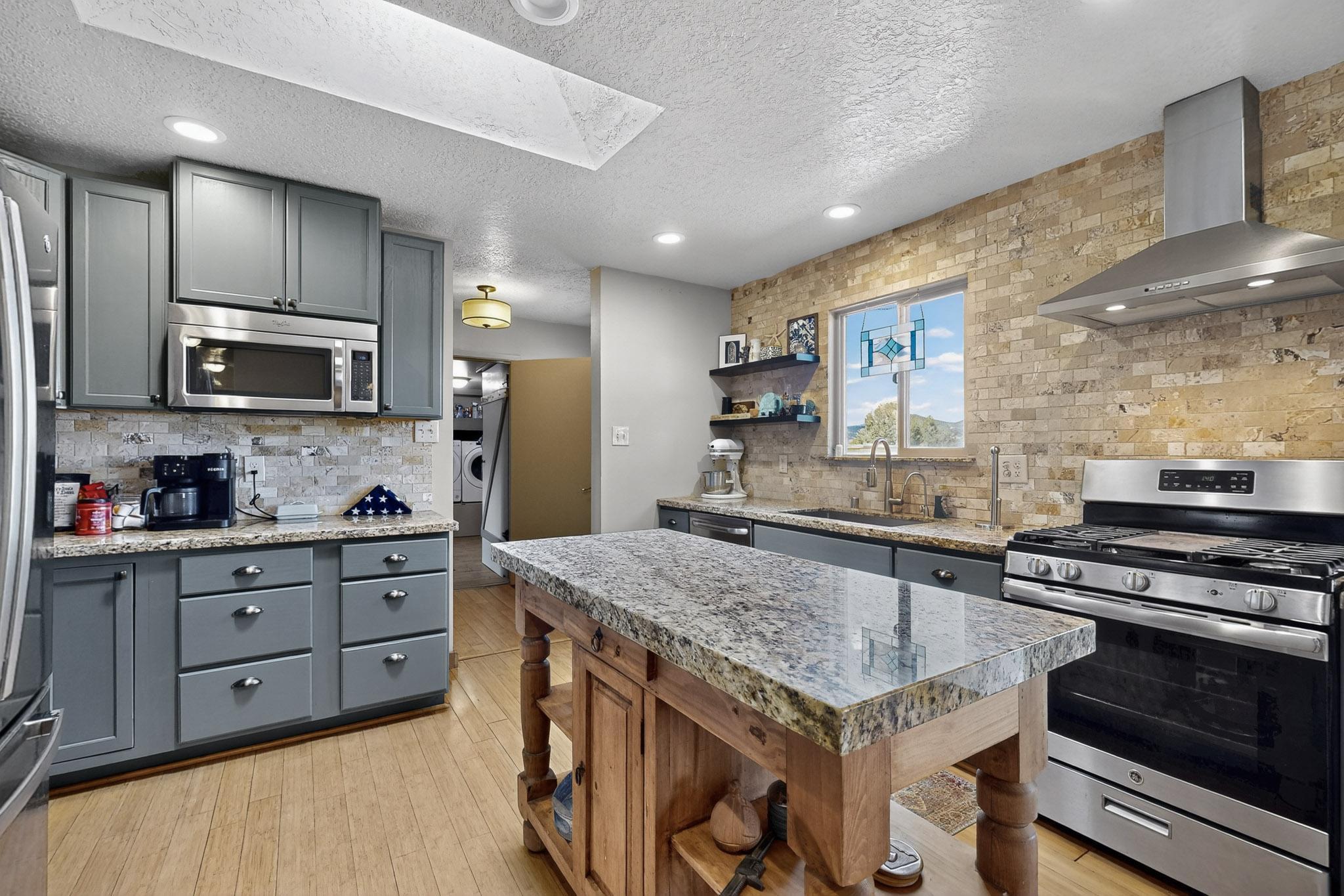 Set on 4.9 acres of peaceful land, this updated country-style home blends comfort, charm, and function. Inside, enjoy modern upgrades throughout and a warm, welcoming feel. Outside, there's plenty of room to roam, garden, or simply soak in the quiet scenery. The property includes a detached 1600 sqft workshop with office space, 220v power, and water ideal for projects, hobbies, or remote work plus an additional shed for storage. Fresh exterior paint gives the home a crisp look, and a new roof will be installed for added peace of mind. A 3,000-gallon water tank and outdoor fire suppression system are included. With horses permitted and open skies all around, this property offers the perfect mix of country living and everyday comfort.