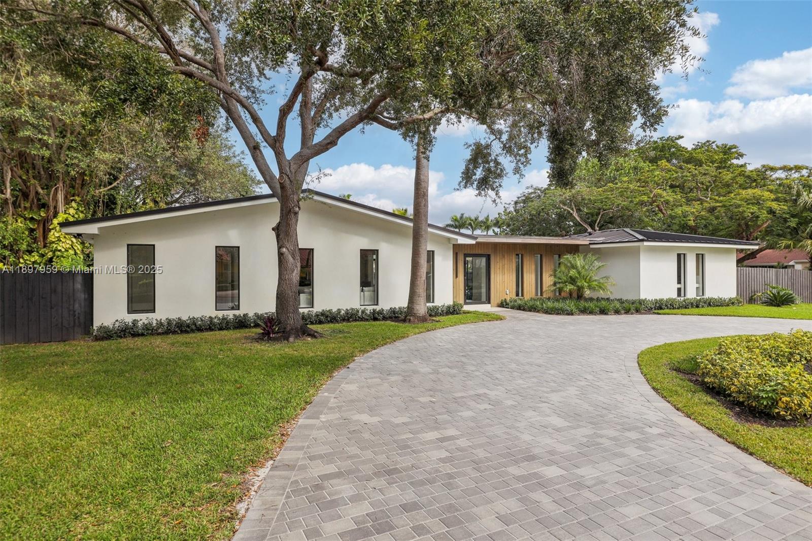 Experience modern luxury and timeless elegance in this stunning 4-bedroom, 3-bath corner-lot residence on a spacious 0.46-acre lot in Palmetto Bay. This beautiful home features a bright open layout with sleek custom finishes and abundant natural light streaming through floor-to-ceiling impact glass. The gourmet kitchen offers premium appliances, a large island, and bespoke cabinetry flowing seamlessly into the living and dining areas. The primary suite provides a serene retreat with a spa-inspired bath and custom closets. Step outside to your tropical oasis with a sparkling pool, lush landscaping, and a majestic banyan tree—perfect for relaxing or entertaining. Ideally located near top-rated private schools, parks, and the Deering Estate.