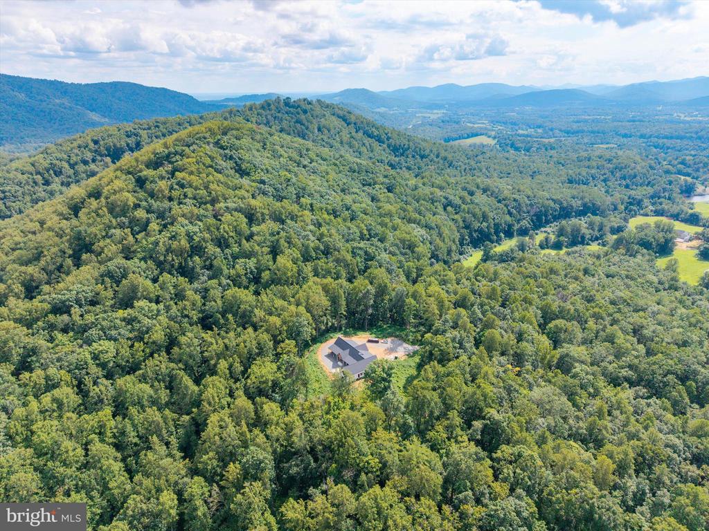 ONCE IN A LIFETIME LUXURY NEW CONSTRUCTION IN THE PRESTIGIOUS BLANDEMAR ESTATES SUBDIVISION! This luxury gem is nestled on 24 private acres with panoramic views of mature hardwoods and the breathtaking Blue Ridge Mountains. This exceptional 4,806 SF estate with a FLAT HOMESITE offers refined one-level living with 5 spacious bedrooms and 4 beautifully appointed bathrooms. A small, serene creek meanders through the edge of the property, enhancing the peaceful, secluded setting. Inside, the custom design and finishes are second to none ”” from the gourmet kitchen with panelized appliances, floor-to-ceiling cabinetry, and a large walk-in pantry, to the vaulted and tray ceilings, custom-stained plank ceilings, and expansive open-concept living spaces (more....) Entertain in style with a dedicated wine area featuring 300-bottle built-in wine storage coolers, a wet bar with sink and kegerator, and a cozy lounge with fireplace. The luxurious master suite wing and separate full guest suite offer privacy and comfort, while a fitness room, sauna/hot tub connection, and outdoor shower elevate the lifestyle. Step outside to expansive covered porches with fireplaces perfect for year-round enjoyment of the mountain views. Additional features inc