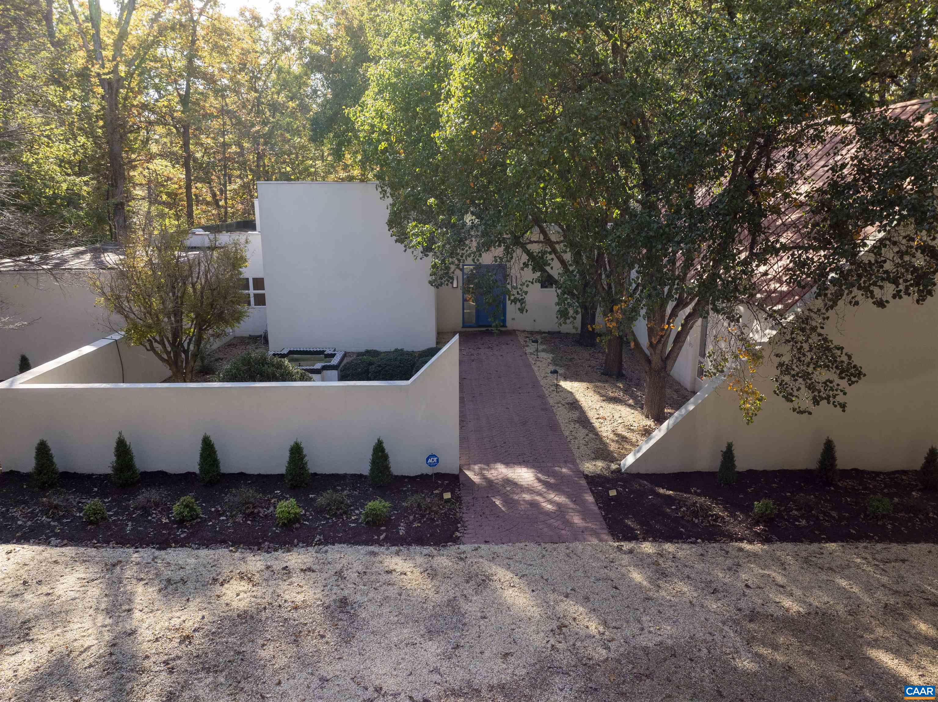 Beautiful contemporary residence, circa 1995, designed by noted Charlottesville architect Peter Sheeran (1950–2010) in collaboration with the home’s original owner, renowned American artist Honoré Sharrer (1912–2009). Her obituary is included in the Documents section of this listing. With over 4,000 finished square feet, this striking home features generous, light-filled rooms with soaring ceilings ranging from 10 to 18 feet and expansive walls of glass. The main level includes a spacious living room with a see-through fireplace, an adjoining dining room, and a large eat-in kitchen perfect for gathering. Additional spaces include a magnificent library/office with built-in bookshelves reaching 18 feet high and crowned by an octagonal skylight, as well as a sizable artist’s studio (approximately 15' x 27') featuring high ceilings, large north-facing windows, and additional skylights providing ideal natural light. The home offers three bedrooms, two and a half baths, a large laundry room, and an attached two-car garage. Outdoor living on 2.2 acres is equally impressive, with a broad rear terrace and fenced backyard. The home has great privacy, and convenient proximity to all locations in Charlottesville & UVA!