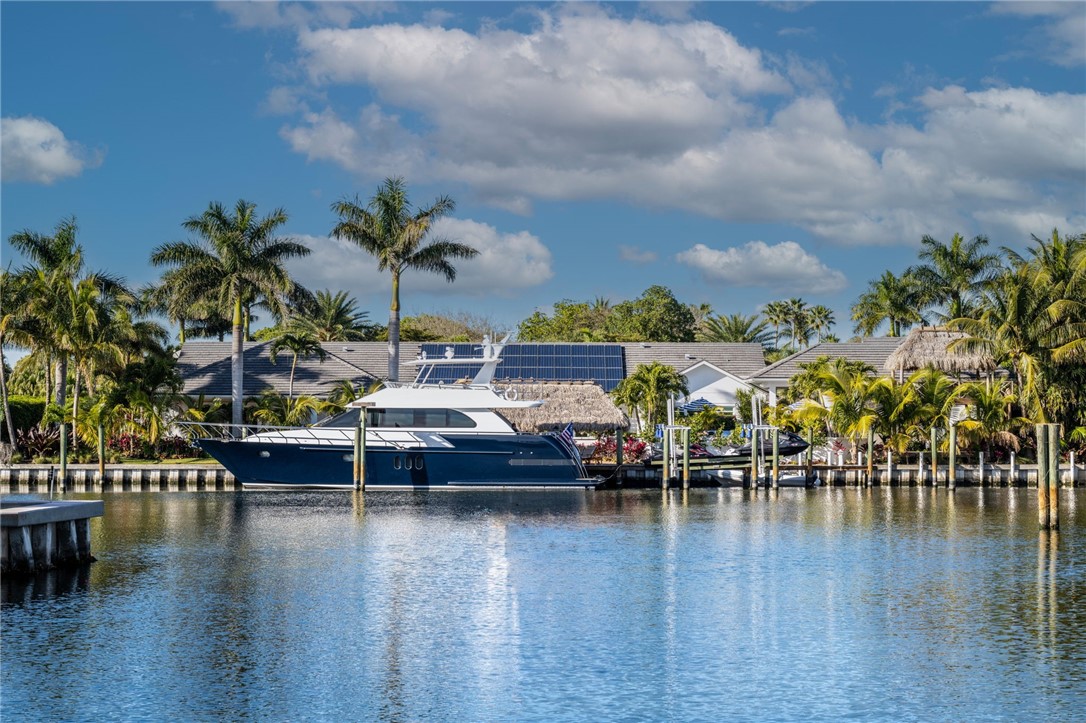 With over 184 feet of PROTECTED DEEP-WATER frontage, a 98’ Ipe wood dock, 24,000 LB lift, & quick access to the intracoastal, this IS a boater’s dream! A 2023 renovation has turned this 5,500+ SF home into a modern, luxurious retreat that seamlessly blends indoor & outdoor living. Privacy is enhanced w/lush landscaping & authentic Chickee Tiki huts, creating multiple areas for entertaining or enjoying the Florida lifestyle. The spacious floor plan has been updated w/gourmet kitchen, all impact glass sliders & windows, spacious room sizes & private en-suite BDRMS. Nothing has been missed here!