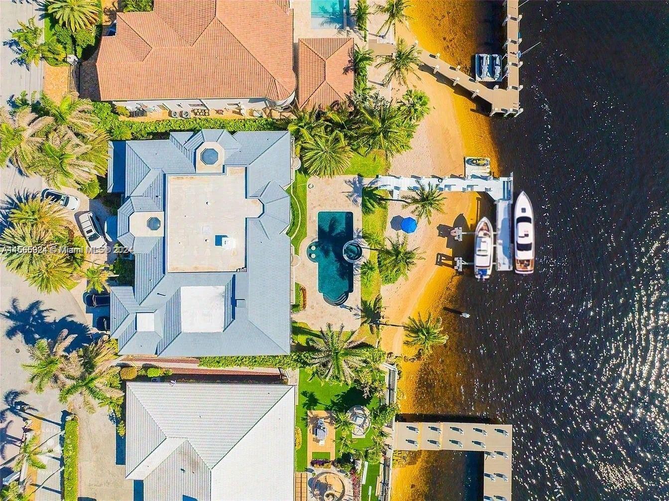 The only estate available with a *private beach* and 100 feet of direct Intracoastal water frontage in a tranquil no-wake zone, just 5 minutes from the inlet. This stunning property offers an unparalleled oasis on a prime 18,000+ square foot lot. The elegant 5-bedroom home spans over 6,500 square feet of luxurious living space and includes a separate guest suite with its own private entrance. Grand foyer leading to floor-to-ceiling windows showcasing the stunning outdoor vistas. Large kitchen, wet bar, fireplace and private home theater. Outdoors, enjoy the ultimate in waterfront entertainment with an extended L-dock featuring a boat lift and jet ski dock, complemented by an oversized covered outdoor space. The estate sits on a spacious 175-foot-deep lot.