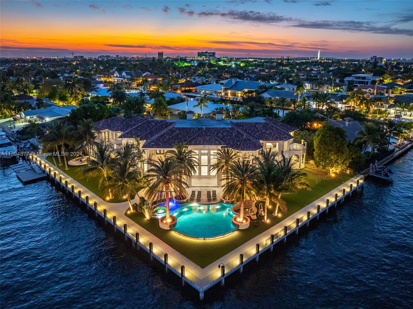 Welcome to an exquisite point lot estate in Coral Ridge Country Club, Ft Lauderdale. This SE estate boasts striking design, soaring ceilings, and 330' of waterfront, ideal for boaters. Custom finishes highlight the luminous open floor plan. Features include a grand great room, marble and wood floors, Crestron smart home system, VIP suite, gym, club room, loft, theater, and elevator. The chef's kitchen, with quartzite countertops, butler's pantry, and top-of-the-line appliances, flows into the family room. Expansive pocket doors enhance indoor-outdoor living. The primary suite offers water views, a sitting area, and dual bathrooms with a soaking tub and spa shower. Outdoors, enjoy covered areas, a pool, and a gourmet summer kitchen.