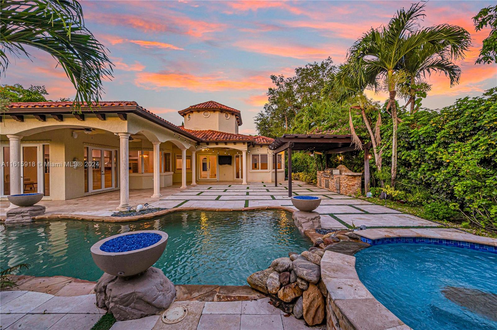 An Italian-inspired family villa situated on a quaint, tree-lined street in South Pinecrest. Situated on a large, 17K+ square feet corner lot, this newer-construction home is designed for family living & refined entertaining in a resort-like setting. The configuration allows for open concept in common spaces & private living quarters in the wings ; Also ideal for "work from home" setup. The generously sized kitchen looks out over the family room w/ a wide exposure of the outdoor entertaining area & pool terrace. The outdoor living space transforms you into a lush, tropical oasis w/ mature landscaping, travertine pavers, & custom pergola w/ outdoor kitchen. The alluring pool is highlighted by a flowing waterfall & fire features to dazzle. Ample space to park boats or RV's. Prime location