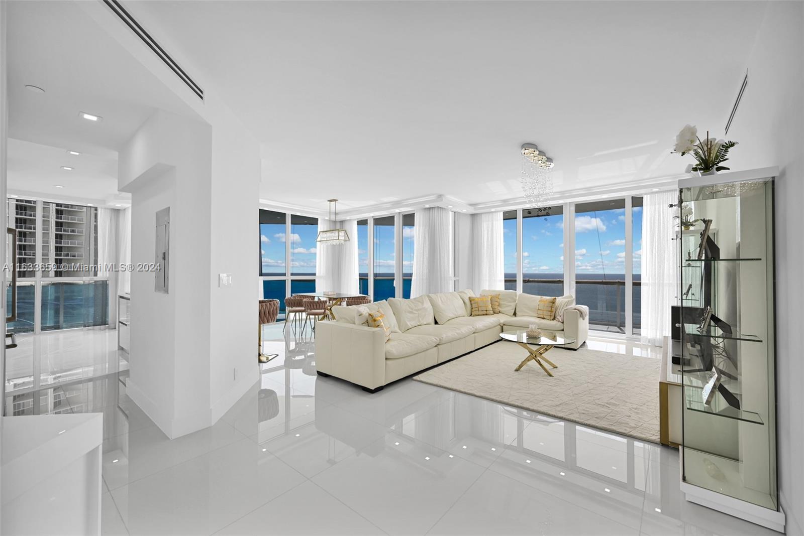 Welcome to this beautifully remodeled Penthouse that has undergone a complete transformation with direct ocean and city views. This turn-key features an open floor plan with an abundance of natural light flowing through impact hurricane oversized windows. With 10 feet ceilings, custom closets and lighting, beautiful white porcelain floors create an inviting ambiance, perfect for gathering with family and friends. Custom modern kitchen, with a large central island, is the heart of the space, marble countertops, café appliances. The adjacent dining area offers ample seating for family meals or entertaining guests. True Luxury Resort Style Living within a building that features; Full Service Private Beach Club, private restaurant, café, 24 hour security, concierge , valet.