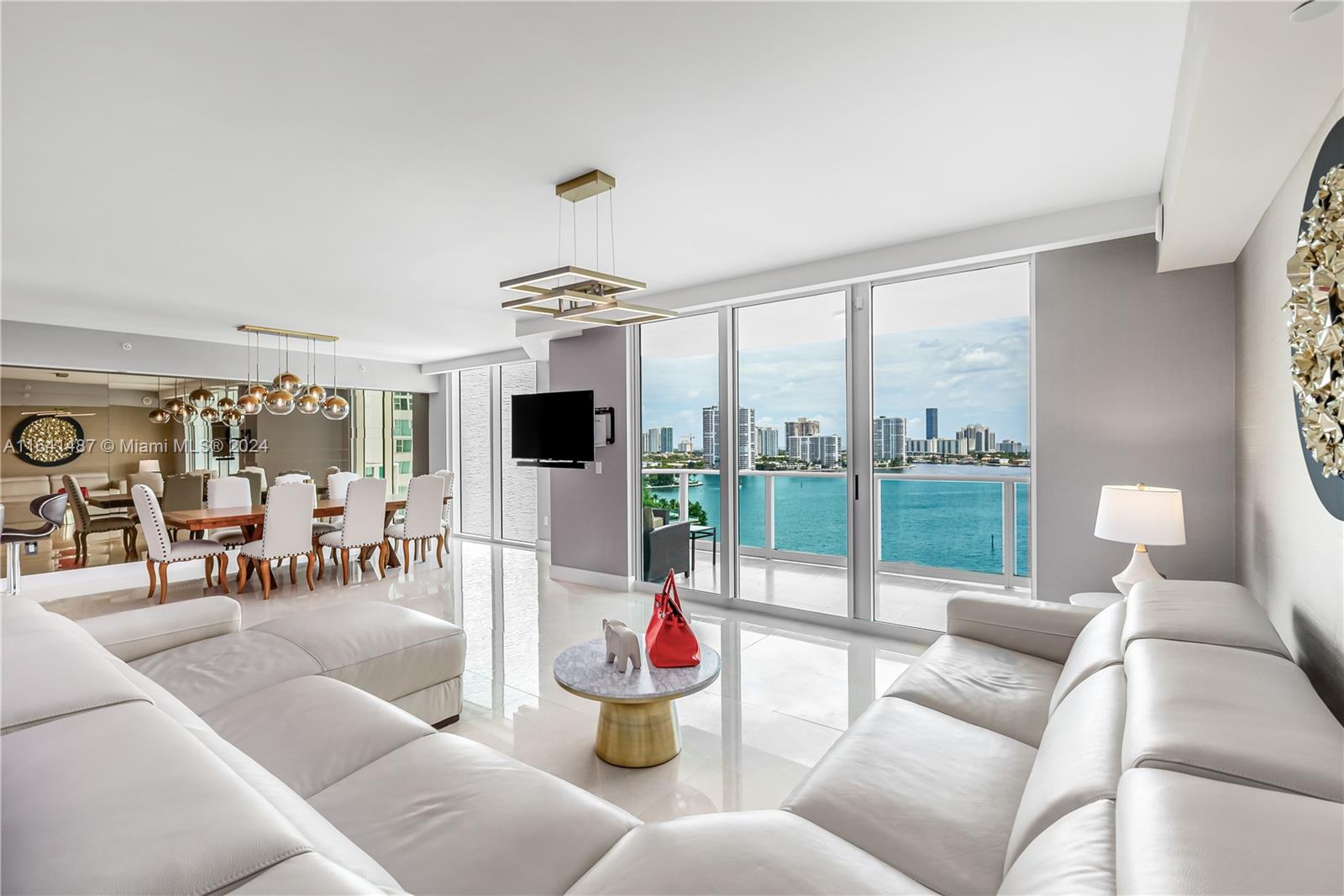 Experience unparalleled luxury and breathtaking water views from this meticulously kept unit in Peninsula II. This expansive residence boasts 3 bedrooms, a den, and 3.5 baths spread across over 3,000 sq ft of refined living space. Enjoy the beauty of the Intracoastal and city skyline and ocean views from the flow-through unit's two private balconies. The home is elegantly appointed with marble floors and comes fully furnished, ready for you to move in.The property includes a generous Laundry room, ample walk-in closets, a large storage unit, and one deeded self-parking space. The community offers resort-style living, includes: 24-hour security, concierge services, valet, a state-of-the-art spa and fitness center, sauna, children's playroom, tennis courts, BBQ area, and two pools and more