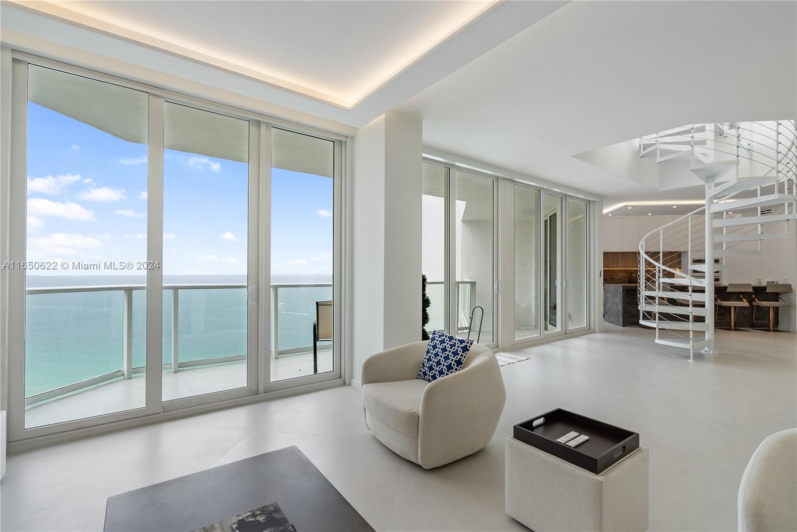 Experience modern coastal living in this fully renovated, two-story residence with breathtaking ocean views and sophisticated design. This 3-bedroom, 3-bathroom home features a den, 2,490 sqft of living space, custom wood closets, and a cutting-edge smart home system, ensuring a seamless blend of luxury and convenience. Enjoy flow-through views and exclusive roof rights, along with the ease of assigned covered parking and a private storage unit. Ideally located near Bal Harbour and Aventura Mall, you'll have access to world-class shopping, dining, and entertainment. The 24-hour guard-gated community offers resort-style amenities, including a private beach club, gourmet restaurant, state-of-the-art fitness center, pool, sauna, beauty salon, spa, tennis courts, marina, and more.