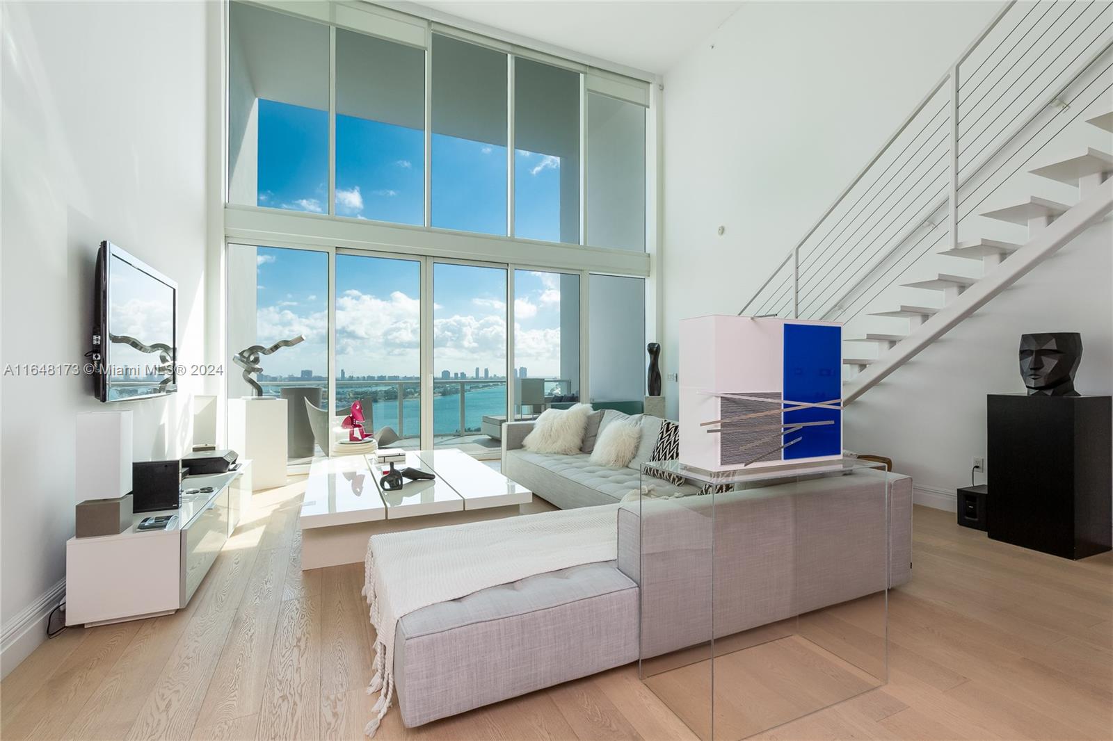 Stunning two-story loft at Ten Museum Park with sweeping views of Biscayne Bay and the Miami Skyline. Situated in the vibrant heart of Miami, this 1,802 sq. ft. residence boasts an expansive open layout, 20 ft. ceilings, and abundant natural light. The first floor offers a stylish dining area, a custom kitchen with premium appliances, a bedroom with an ensuite bathroom, a laundry room, and a powder room. The second-floor master suite features a luxurious bath with a glass-enclosed shower, soaking tub, double vanities, and a walk-in closet, complemented by motorized blackout drapes. FULLY FURNISHED! New air conditioning unit installed in November 2024.