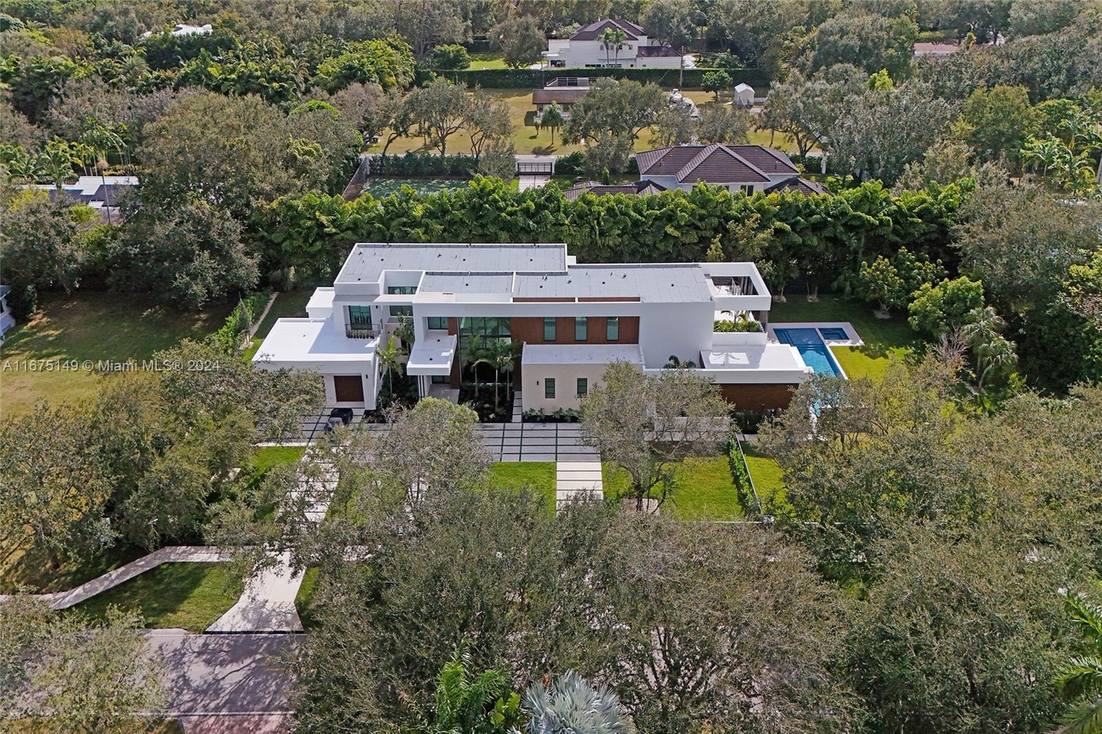 Contruction Just Completed! Stunning modern home in prestigious Pinecrest, nestled on a lushly landscaped 35,360 sq ft lot. This architectural gem features floor-to-ceiling windows, seamlessly integrating interior and exterior spaces. With over 16,000 sq ft of luxurious living, it includes 7 bedrooms, 8.5 baths, 3-car garage, a gym and a den. A breathtaking entry showcases a floating staircase over a sleek interior garden. The double-height dining and living room overlooks a tranquil water feature, leading to an outdoor entertaining area. The open gourmet kitchen, equipped with top-of-the-line appliances, flows into an expansive family room. A spacious covered terrace with a fully equipped outdoor kitchen overlooking the pool, spa, and lush backyard make it perfect for entertaining.