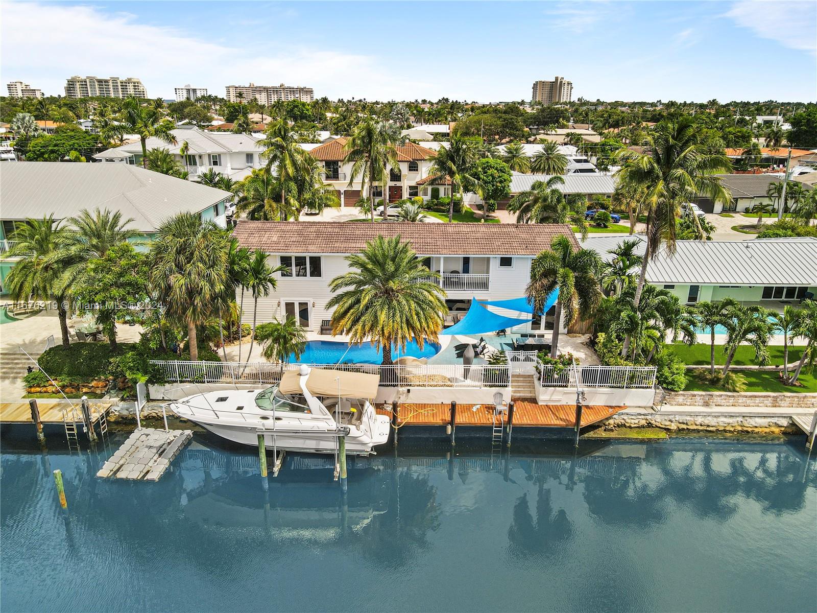 Embrace unparalleled waterfront luxury in this beautifully updated 5-bedroom, 4.5-bathroom home, situated in the prestigious Venetian Isles of Lighthouse Point. With a private boat dock and neptune boat lift, this masterpiece offers 90 feet of prime dockage on one of the widest, most coveted canals - boasting over 120 feet across and no fixed bridges, granting a seamless 5-minute ride to the open ocean. Inside, enjoy over 4,400 sqft of expansive layout featuring five separate rooms for living, dining, and entertainment, along with a grand primary suite, dedicated office, generous walk-in closets, and a spa-like bath. Upstairs, three generously sized bedrooms and a versatile den provide a private retreat. This exceptional residence combines luxury, comfort, and elegance for coastal living.