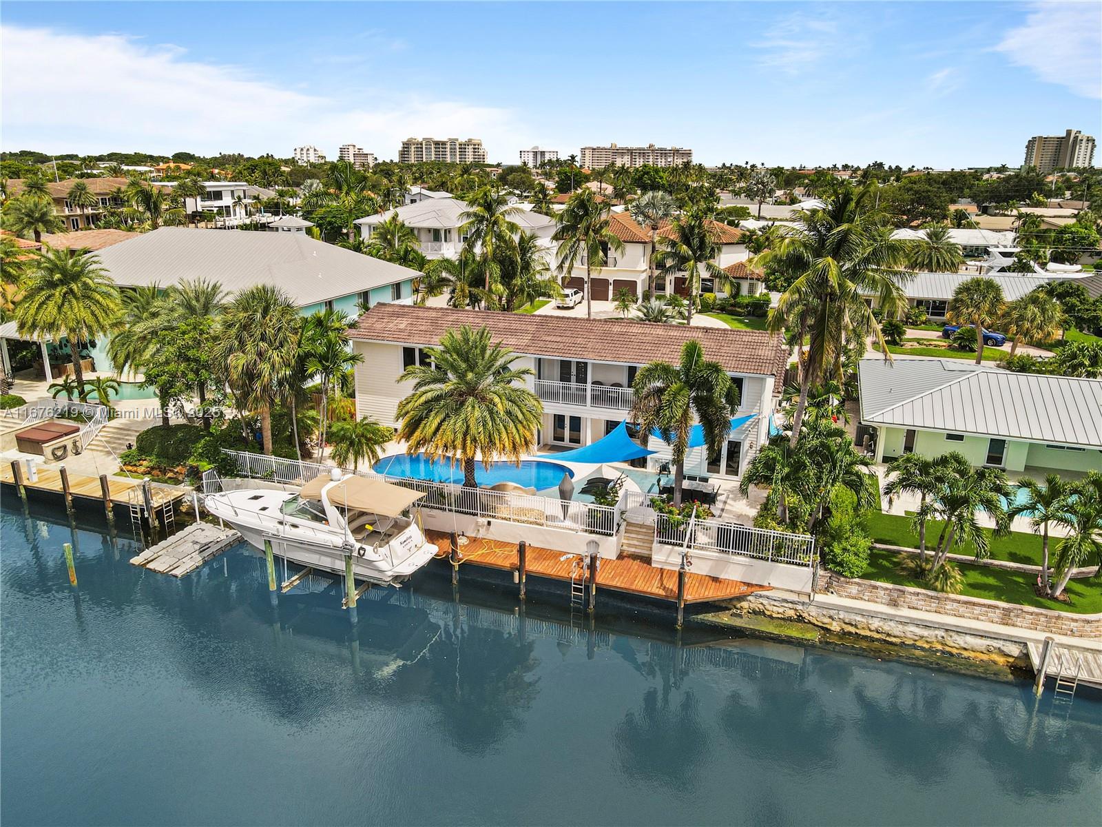 Embrace unparalleled waterfront luxury in this turnkey 5-bedroom, 4.5-bathroom home, situated in the prestigious Venetian Isles of Lighthouse Point. With a private boat dock and neptune boat lift, this masterpiece offers 90 feet of prime dockage on one of the widest, most coveted canals - boasting over 120 feet across and no fixed bridges, granting a seamless 5-minute ride to the open ocean. Inside, enjoy over 4,400 sqft of expansive layout featuring five separate rooms for living, dining, and entertainment, along with a grand primary suite, dedicated office, generous walk-in closets, and a spa-like bath. Upstairs, three generously sized bedrooms and a versatile den provide a private retreat. This exceptional residence combines luxury, comfort, and elegance for coastal living.