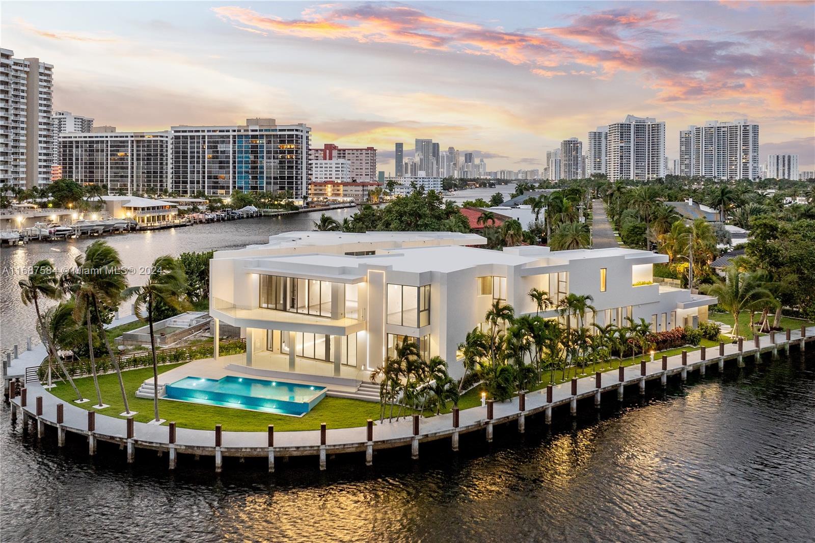 Welcome to this BRAND NEW architectural gem located in the exclusive waterfront community of Golden Isles in Hallandale Beach. Situated on a 16,000 SF point lot along the Intracoastal Waterway, this trophy home can accommodate a 200 FT Mega Yacht. Interiors include 8,000 SF of meticulously designed living space. Five bedrooms upstairs, two downstairs, plus a gym and office—all crafted with premium materials and custom millwork. The 1,400 SF master suite features separate his-and-hers bathrooms and closets for ultimate privacy. Additional interior highlights include a custom European kitchen, wet bar, wine cellar, elevator, and media room. Enjoy a resort-style pool, summer kitchen, 315 FT OF WATER, BRAND NEW concrete sea wall & No fixed bridges.