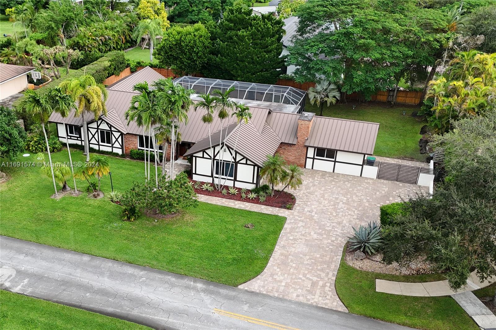 Spacious and updated corner property on a cul de sac in the heart of Pinecrest. Move right in or put your own personal touches on this unique Tudor style home with paved driveway, metal roof, and impact windows/doors. Double doors welcome you into a foyer, formal living, and dining room. Renovated eat-in kitchen features a picture window and French doors to your covered terrace with wet bar and pool. The adjacent family room exudes warmth with wood beam ceilings & wood-burning fireplace. A flexible bedroom, playroom, and/or home office with full bath sits off the family room. Oversized primary suite has two walk-in closets plus bathroom with standalone tub & double vanity. Indoor laundry room, powder room, and two-car garage complete this well-appointed home. **Some photos virtually staged