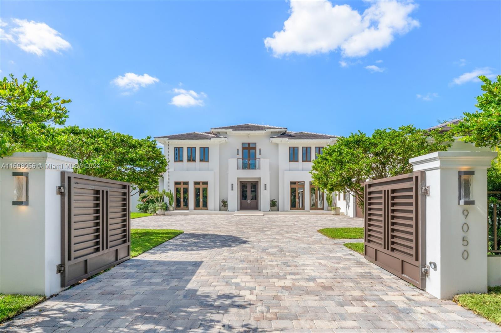 Welcome to this 2-story retreat, nestled in one of Pinecrest's most sought-after locations. The residence boasts impact windows throughout, offering views of the sprawling 37,990 SqFt lot. This home features 8 BD, 9.5 BA, a 3-car garage, generous living spaces, service quarters, and versatile rooms ideal for a gym or home theater. The primary ste located on the ground floor is a private haven with a sitting area, 2 walk-in closets, a spa-like tropical bathroom, and serene views of the sparkling pool. The home’s living spaces are enhanced by a wine display and bar, soaring volume ceilings, designer lighting, and spacious terraces. Step outside to enjoy the brand-new outdoor kitchen, set in a lush backyard oasis surrounded by mature mango trees.