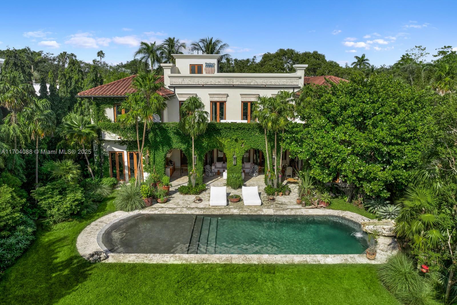 Welcome to this stunning three-story mansion in Coconut Grove's Hughes Cove, where luxury meets tropical paradise. Offering breathtaking ocean views, the home is surrounded by the award-winning White Dove Garden, recognized with the 2024 Design Award of Excellence by Raymond Jungle. Inside, spacious living areas filled with natural light, a chef’s gourmet kitchen, and elegant finishes create a one-of-a-kind atmosphere. Outdoors, enjoy a saltwater pool, tranquil pond with African Cichlids, yoga pavilion, sauna, soaking tub, a 40 foot dock, and a communal tennis court. A whimsical coconut shell elevator adds a unique touch to this exceptional property.