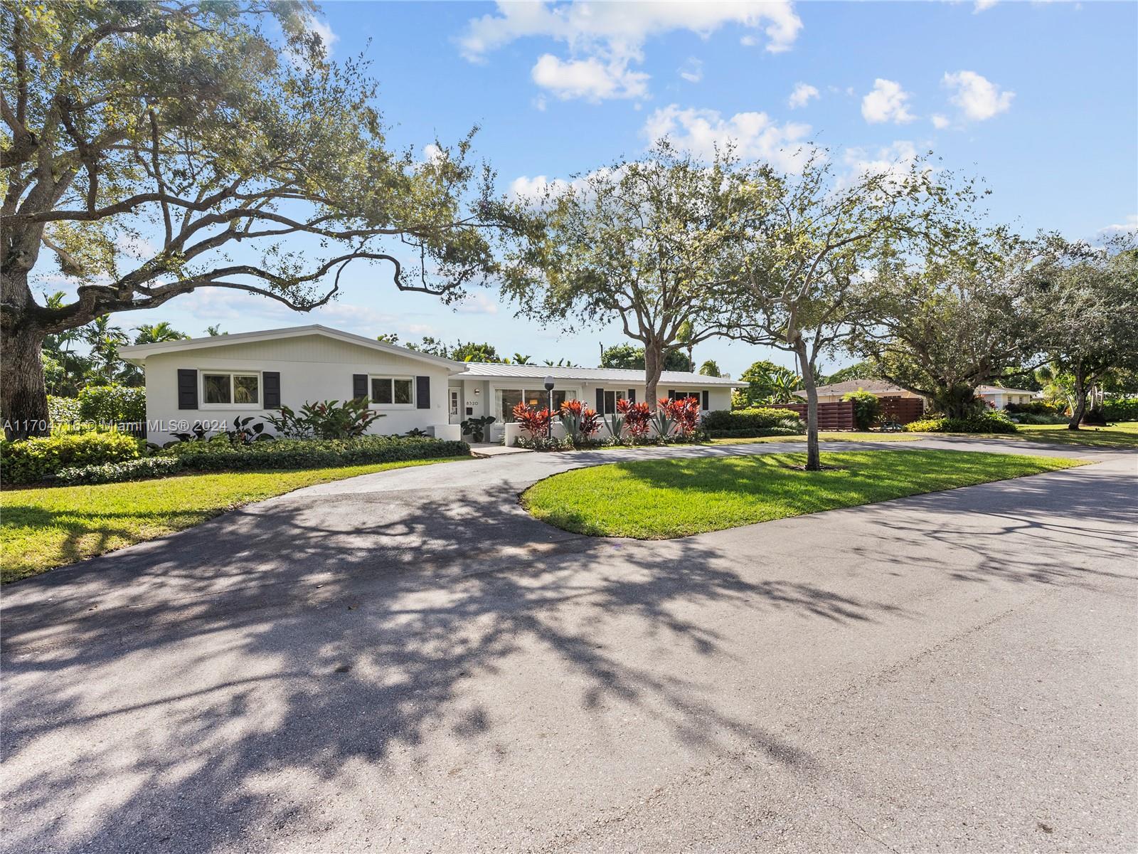 Charming Ranch-Style Home– Perfect for Entertaining! This beautifully updated pool home seamlessly blends modern touches with classic charm. With a fantastic and spacious layout that maximizes space and comfort, this home features a newly resurfaced screened-in pool, a durable metal roof, impact windows and doors, polished terrazzo floors, and stylish wooden interior doors. A walk-in pantry, dedicated laundry room, and a generous 2-car garage add convenience and ample storage, while the lush backyard, maintained by a sprinkler system, offers ample outdoor space. The curb appeal shines with a charming front porch, delightful outdoor lighting, and large circular and side driveway, providing plenty of parking for guests. Located near top-rated schools, this home is perfect for families!