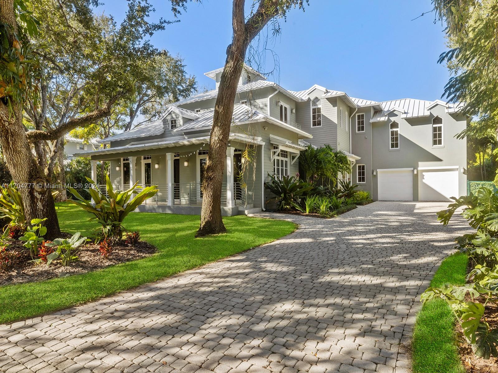 Pristine Key West home with modern twists, high-end finishes, and custom millwork on a coveted low-traffic street in the heart of Pinecrest. Great floor plan for families and entertaining. Gourmet kitchen with island, pantry & eat-in area flows to the large family room with French doors to the covered terrace, summer kitchen, and private yard. Formal living and dining rooms with dramatic volume wood ceilings. The primary suite features two walk-in closets, private balcony and spa-like bathroom. Four additional ensuite bedrooms including a generous apartment-style suite on its own level. Bonus spaces include a large home office with private entrance, wet bar, upstairs den with breakfast bar, and two laundry rooms. Generator with underground gas. Elevator ready. Top public & private schools.