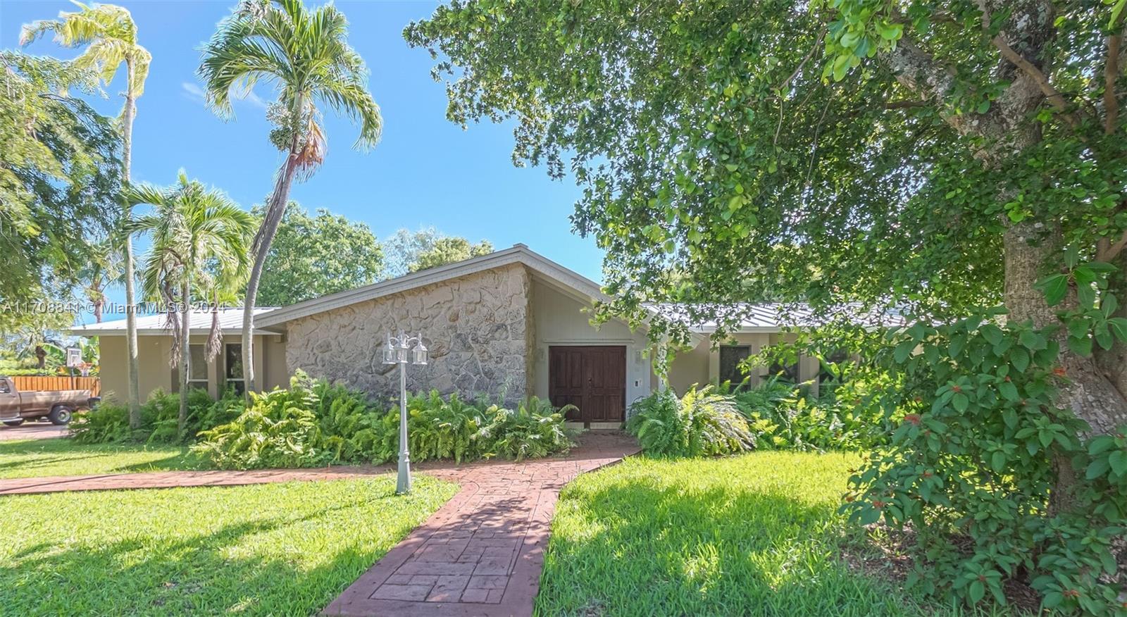 Enjoy pure South Florida canalfront living! 4 bdrm/3 bath home w/ 1bdrm/1 bath guest house. Double door entry to formal living rm w/ cozy fireplace. Updated chef’s kitchen w/ white quartz countertops, counter seating, plentiful cabinetry, opens to spacious family rm, dining area. Split bdrm plan w/ private primary suite, updated bath & walk in closet. One guest bdrm ensuite plus 2 more guest bdms that share a remodeled bath. New metal roof, solar panels, new tile flooring. 2004-built guest house perfect for in-laws quarters features living area, kitchenette & private bdrm. Wonderful fenced backyard w/ screened pool, covered patio, shed & treehouse. Enjoy fishing and cruising the wide, scenic canal right from your own backyard. 2 car side entry garage, partially used for storage.