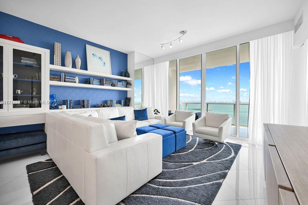 This exceptional, fully furnished unit, expertly designed and decorated by Steven G, offers luxurious living with no detail overlooked. Spanning approximately 1,200 square feet, this one-of-a-kind home features a private foyer, one bedroom, two full bathrooms, and a den that has been converted into a second bedroom. Enjoy breathtaking views of the bay and city from nearly every room. Paramount Bay provides resort-style amenities, including two pools, a fitness center, a private residents' club room, 24-hour security, and front desk assistance.