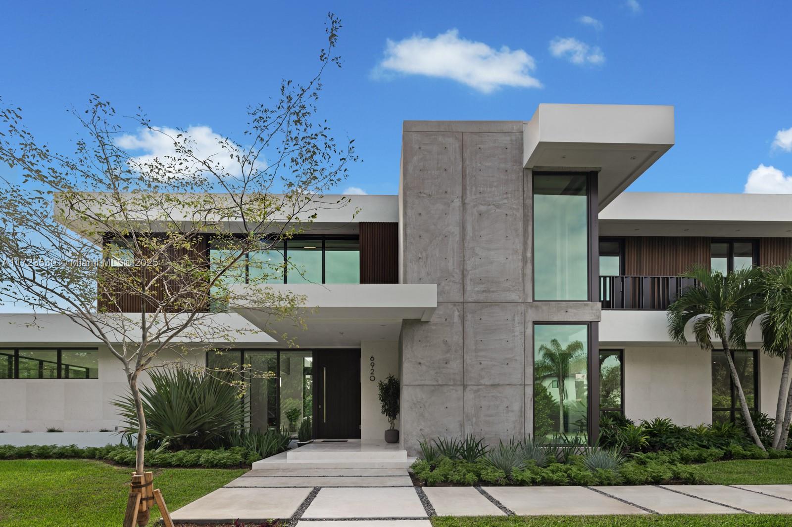 This contemporary masterpiece in Pinecrest, sitting on a 30,492 SqFt lot, is now completed and ready for you to make it your own. The home features a grand great room with double-height ceilings, a steam fireplace, and a custom European chef's kitchen with Gaggenau appliances. The first floor, with marble flooring, includes 2 bedrooms with ensuite baths, 2 powder rooms, and a reading area. Upstairs, you'll find the luxurious primary suite with a spa-style bathroom, sitting area, and boutique-style closet, plus 3 additional bedrooms with ensuite baths. With a 53 ft lap pool, 3-car garage, and large garden, this 6-bed, 6-bath/2 powder room home offers 6,023 sq ft under A/C. Enjoy Pinecrest living with a perfect blend of luxury, design, and functionality. Located near top schools!