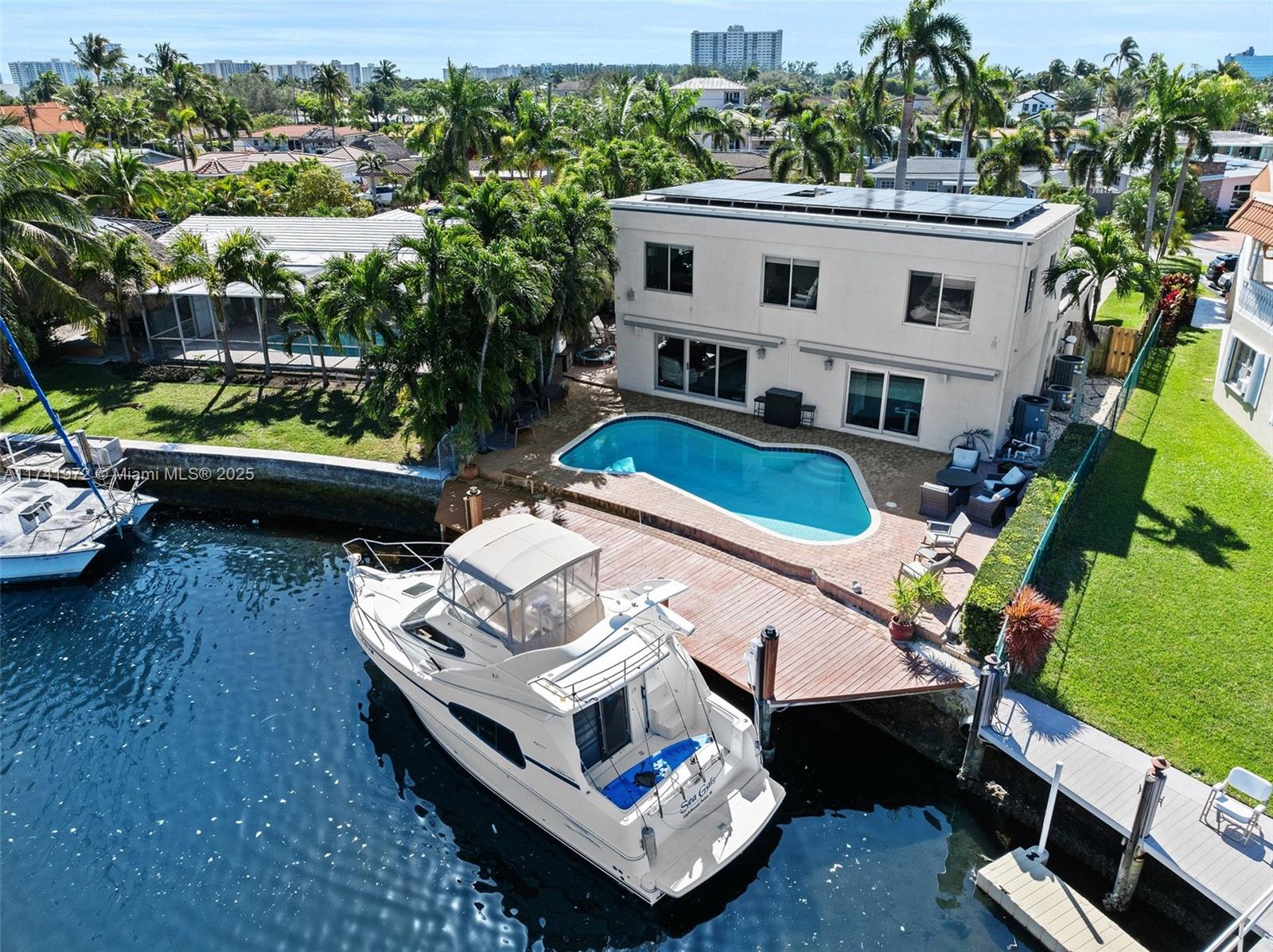Discover coastal luxury in this spectacular waterfront oasis in Santa Barbara Shores! Boating enthusiasts will appreciate the 50-ft dock with ocean access and no fixed bridges, heated pool and beautiful water views. This 4 BR/3BA features 3,058 sq. ft. open and functional living space with master suite and one bedroom on the first floor and two additional bedrooms and versatile loft upstairs.  Gourmet kitchen features wood cabinetry, quartz countertops, and stainless-steel appliances. Embrace modern efficiency with a 2021 roof, solar panels, impact windows/doors and Tesla charging station. Located just minutes from shopping, dining, and less than 10 minutes from the beach. Experience the best of South Florida living in this turnkey waterfront retreat, where luxury meets functionality!