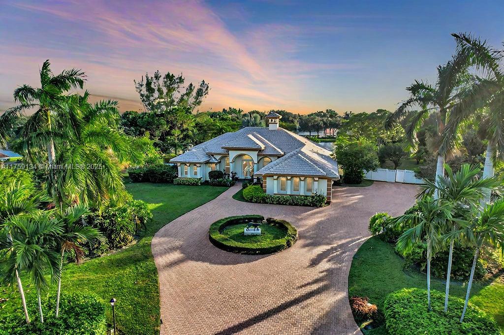 Tucked within the sought-after Sherbrook Estates in Palm Beach County, this elegant home offers the ultimate blend of luxury, comfort, and convenience. Situated on a generous 1.11-acre lakefront lot, the residence features 3 spacious en-suite bedrooms, each with its own private bath. The open-concept layout flows seamlessly into a chef’s kitchen, outfitted with high-end finishes and premium appliances perfect for entertaining or everyday living. Step outside to a resort-style pool overlooking the lake, surrounded by lush landscaping and serene privacy. Ideally located near vibrant Lake Worth, this home offers the best of both worlds: peaceful surroundings and modern living. Additional highlights include a 3-car side-entry garage and a host of upscale amenities. A true must-see