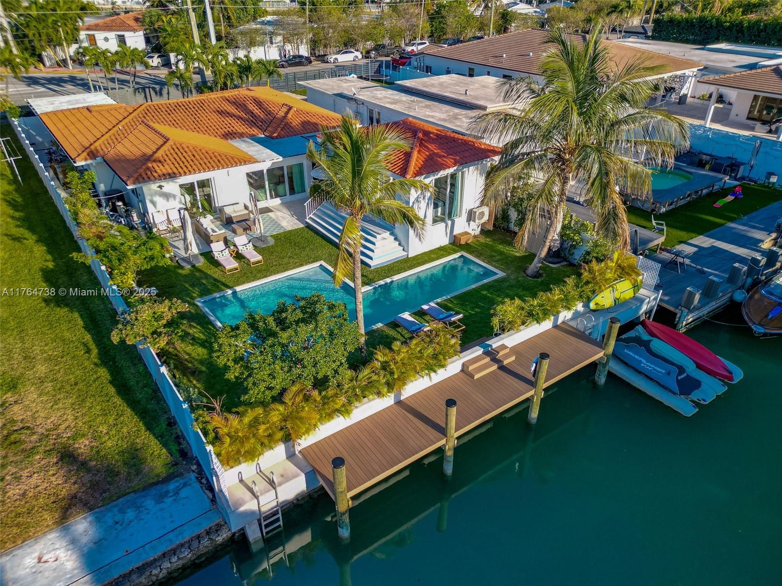 BOATER'S DREAM! NO FIXED BRIDGES! Discover a spectacular upgraded 4-bedroom, 3-bath home offering luxurious living in the Biscayne Point community. Total structure is 2,654sf (house + poolside suite) on a 9,000sf lot. Enjoy 60ft of water frontage, no fixed bridges, and a stunning backyard retreat ready for your waterfront lifestyle. This bright, airy home features spacious rooms, walk-in closet, and impact windows throughout. A newly built poolside suite offers the perfect space for guests or a private office. Step outside to an expansive backyard oasis with a heated saltwater pool (37-ft lap lane), outdoor hot-water shower, kitchen, brand-new seawall, and private dock. Backyard elevation, seawall, and dock built to current regulatory standards.HOUSE SHOWS AMAZING !