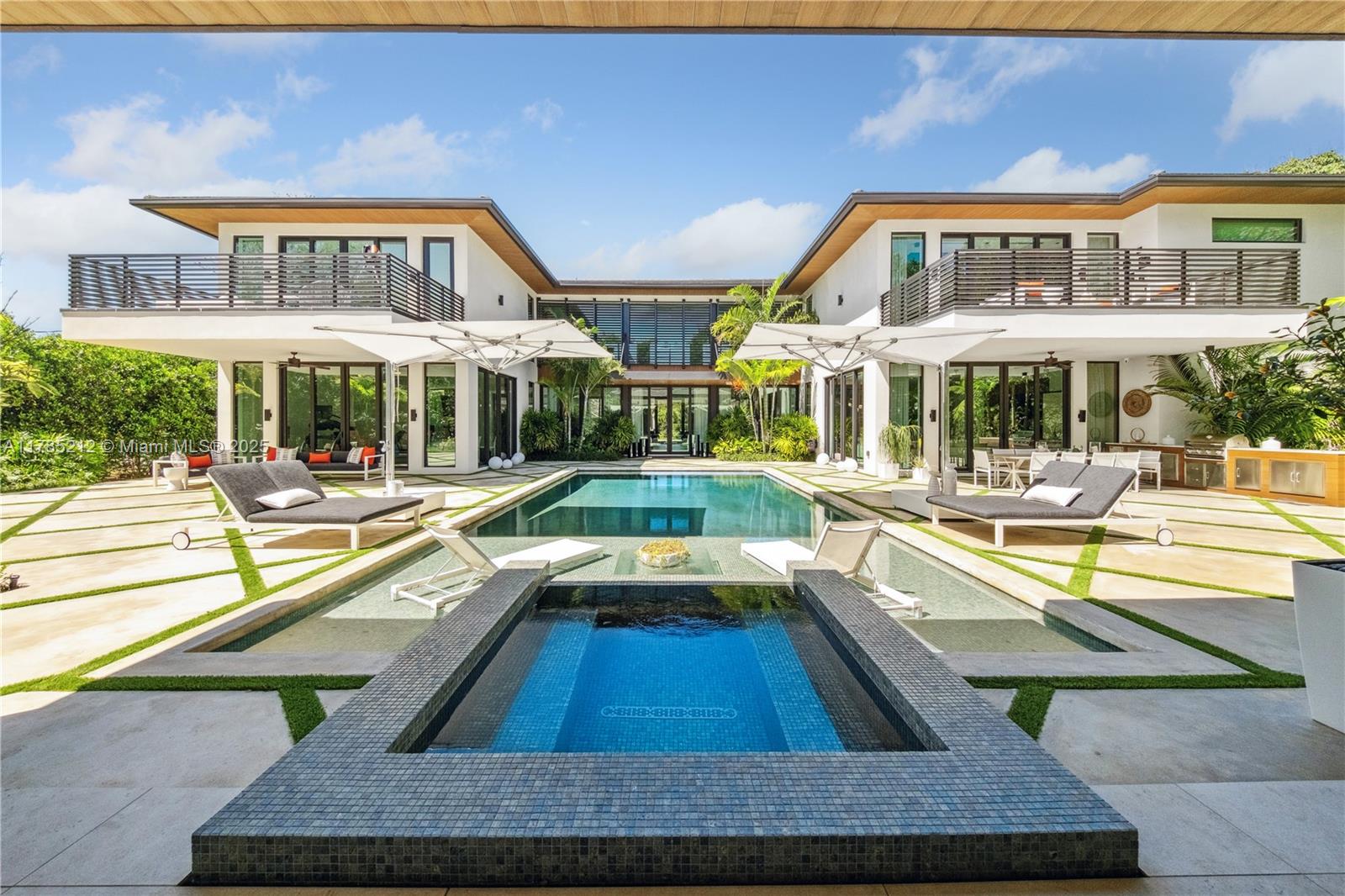 This gated North Pinecrest estate sits on a 50,529 SF lot offering 8 BRs, 9.5 BAs, a theater, gym, office, 3-car garage & double carport. Upon arrival you're greeted by a grand entrance framed in coral rock with elegant water features. Blending modern & traditional design elements, the home showcases refined elegance throughout. Rich Peruvian teak wood accents the high ceilings adding warmth & character. The Italkraft kitchen is equipped with premium Fisher & Paykel and Wolf appliances. All bedroom closets & bathroom vanities are custom-designed by Miacuccina. The outdoor area offers a resort-style experience with a pool, gazebo & summer kitchen all set in a lush tropical landscape. Additional features are a gas generator, wine display, Crestron automation system & a secondary family room.